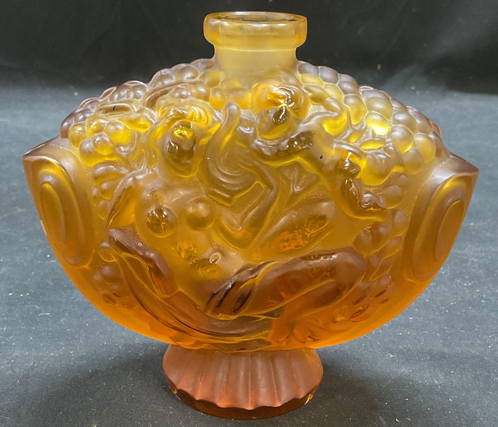Lalique Amber Art Glass Perfume Bottle, France: Vintage Lalique frosted amber art glass perfume bottle. Raised relief surface with nude female figure and cherub. Marked on underside R Lalique, France. Measures approx 5.5 x 2.5 x 4.75 inches. Style