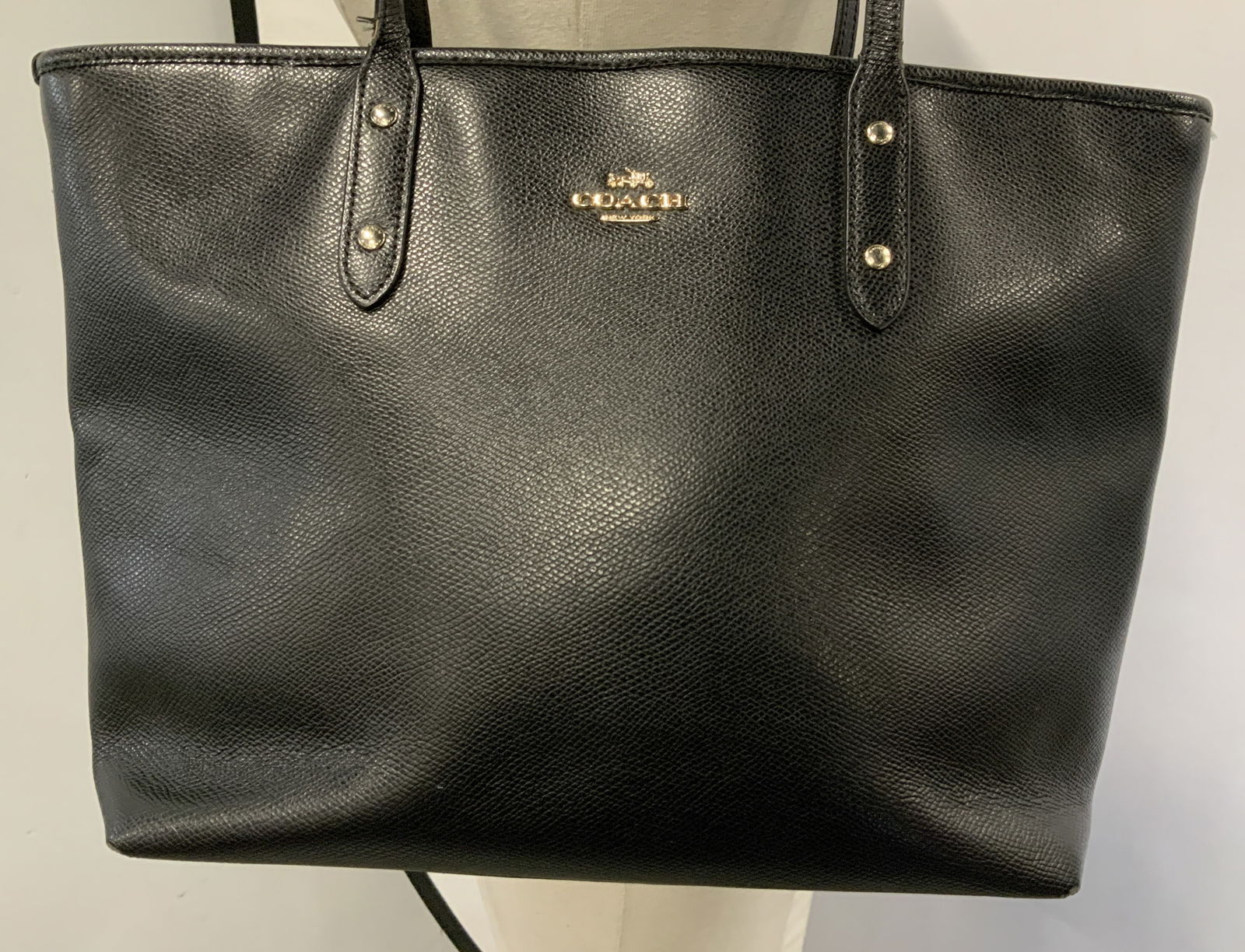 Coach Black Leather Zip Tote Bag NY: Coach tote bag is black toned & leather. Features a zip-top closure & a gold-toned coach emblem. Surface wear consistent to age, use & exposure. Signed & marked. Reads, COACH NY. Measurements: length