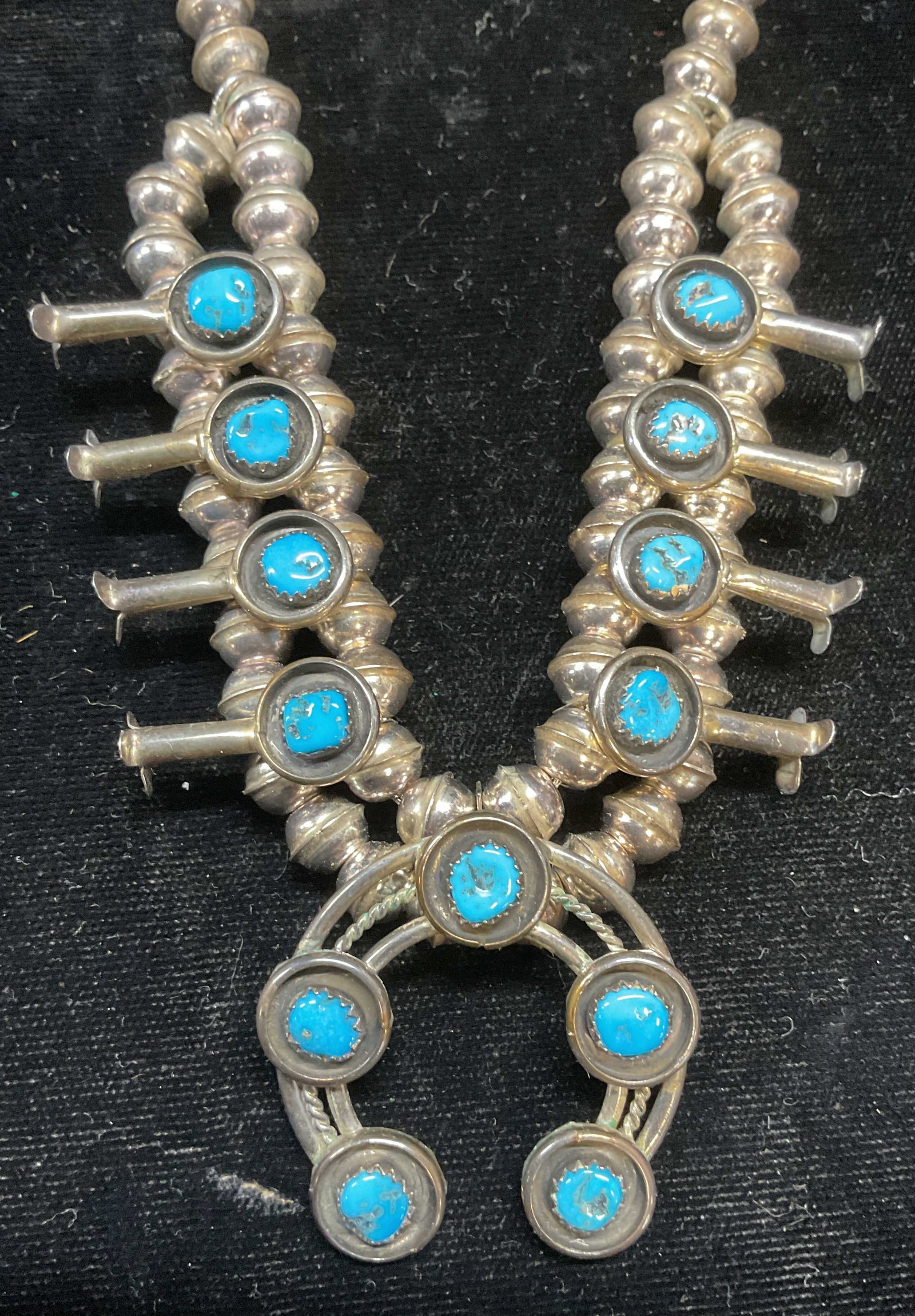 Vintage Sterling Silver & Turquoise Necklace: Vintage sterling silver and turquoise necklace with horse shoe pendant. Navajo squash blossom necklace. Marked sterling. Drop length approx 8 inches. Total weight 46 grams. Includes box. Some scratchi