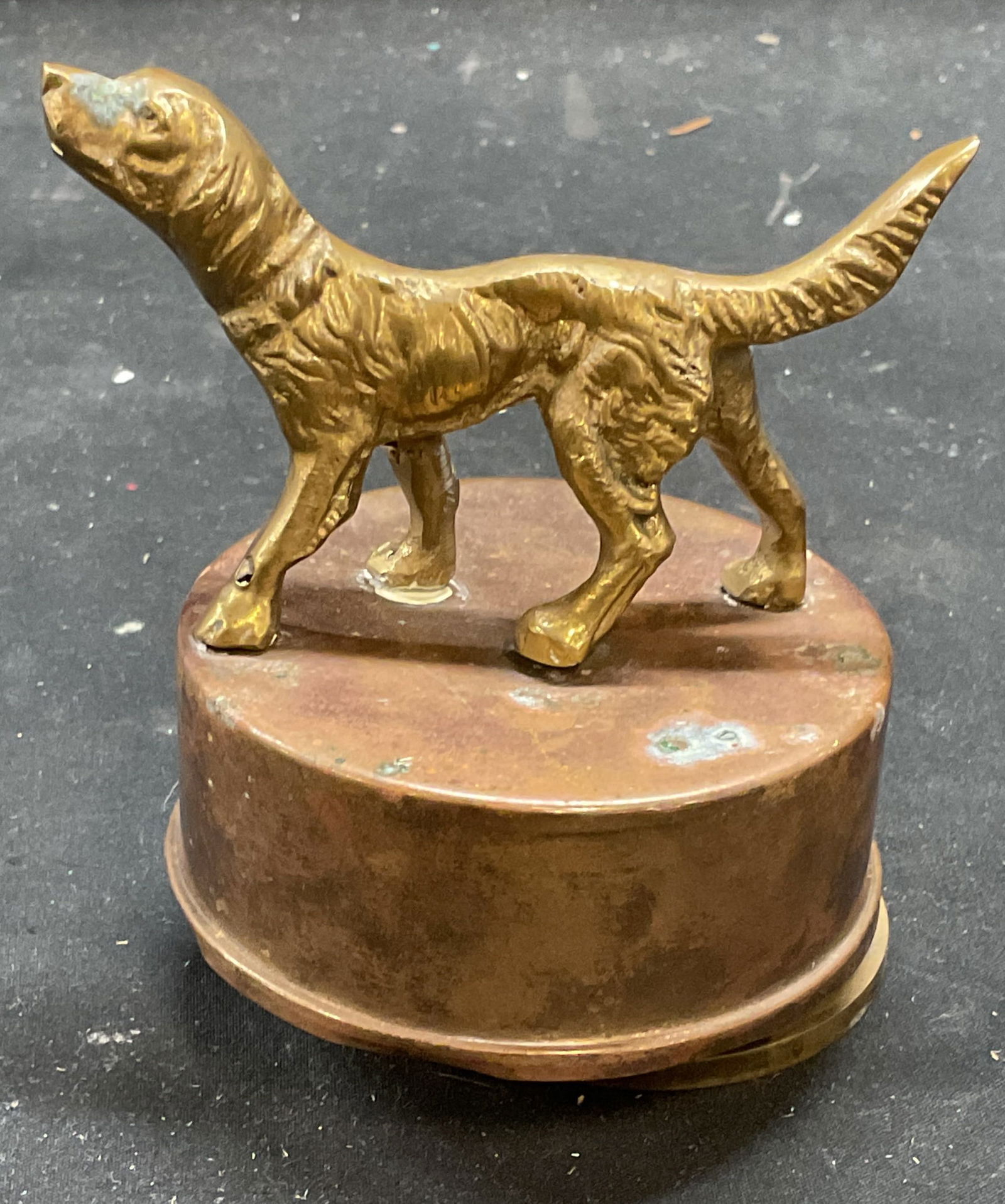 Vintage Brass Dog Spinning Music Box: Vintage brass music box with raised dog finial. Spins on base when wound. Measures approx 3 x 4.5 inches. Wear including patina and warping. Music box, dog music box, brass music box, vintage music bo