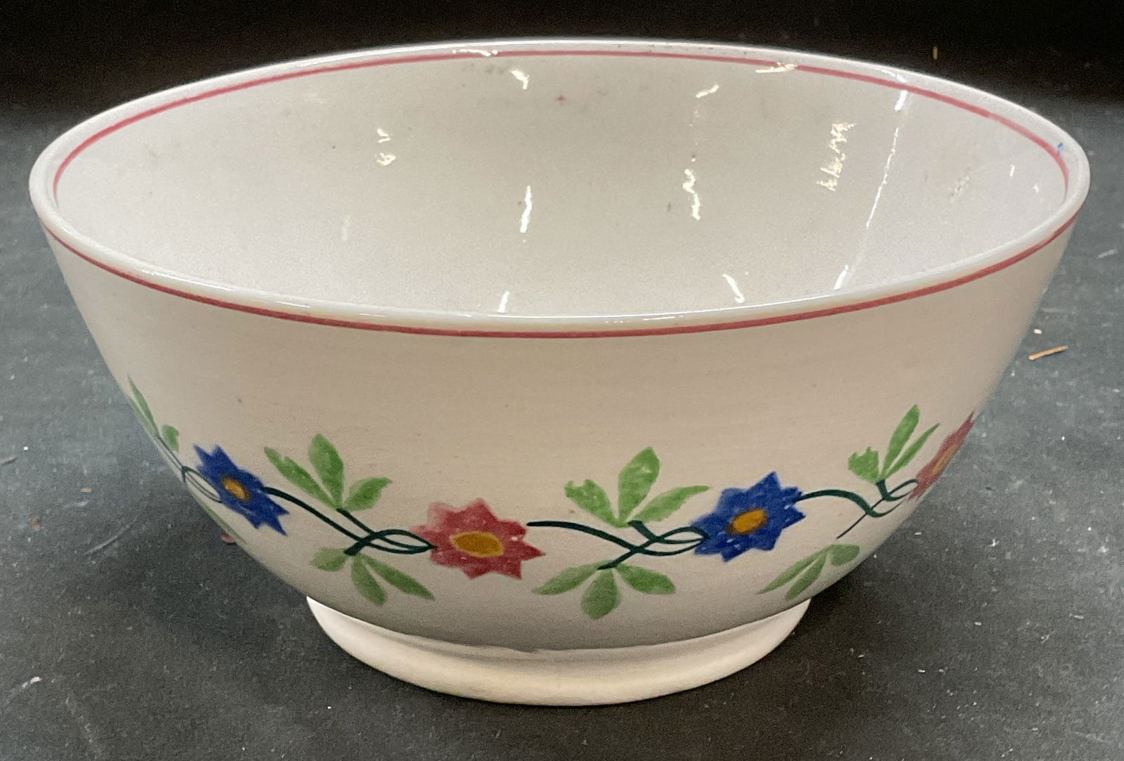 Antique Staffordshire Pottery Floral Bowl: Antique Staffordshire pottery bowl. Spongeware hand painted floral design. Signed with Backstamp. Made in England. Measures approx 7 x 3.25 inches. Wear including crazing and small chip on base. Antiq