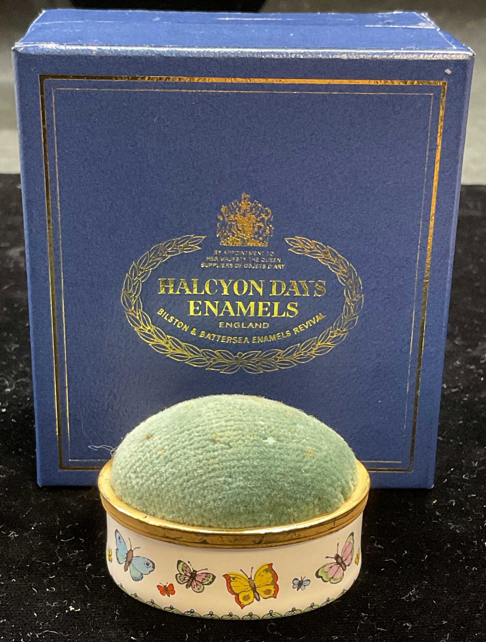 Vtg Halcyon Days Enamel Butterfly Pin Cushion Eng: Vintage Halcyon Days pin cushion. Enameled base with butterfly pattern. Green cushion top. Signed. Made in England. Includes box. Pin cushion measures approx 1.75 x 1.25 x 1.25 inches. Some scratching