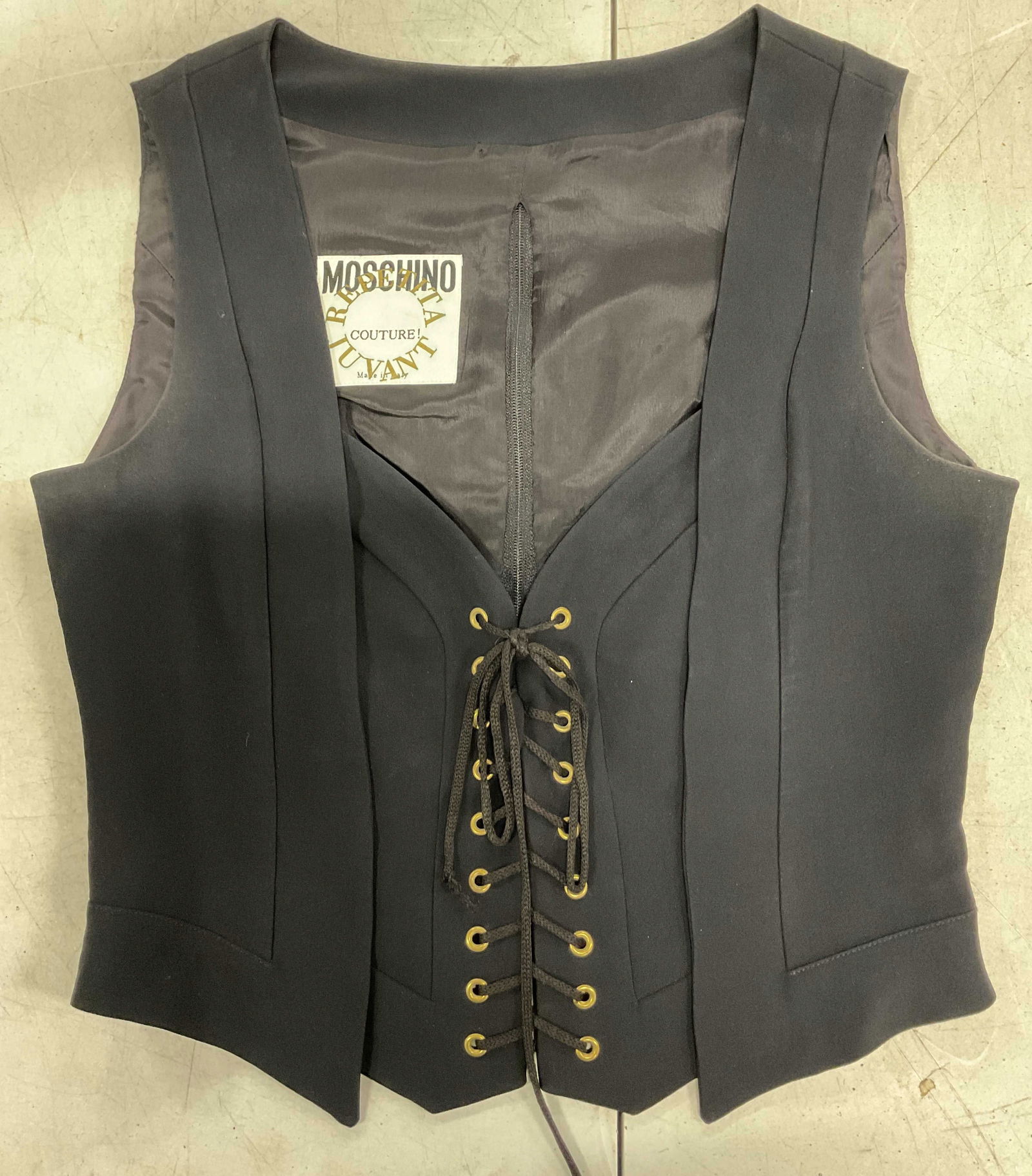 Moschino Couture Black Lace Up Vest Italy: Moschino Couture black lace up vest. Made in Italy. Size 10. Acetate and rayon blend. Shoelace design in front. Zipper in back. Some wear consistent with exposure and blemishes observed. Property of 1