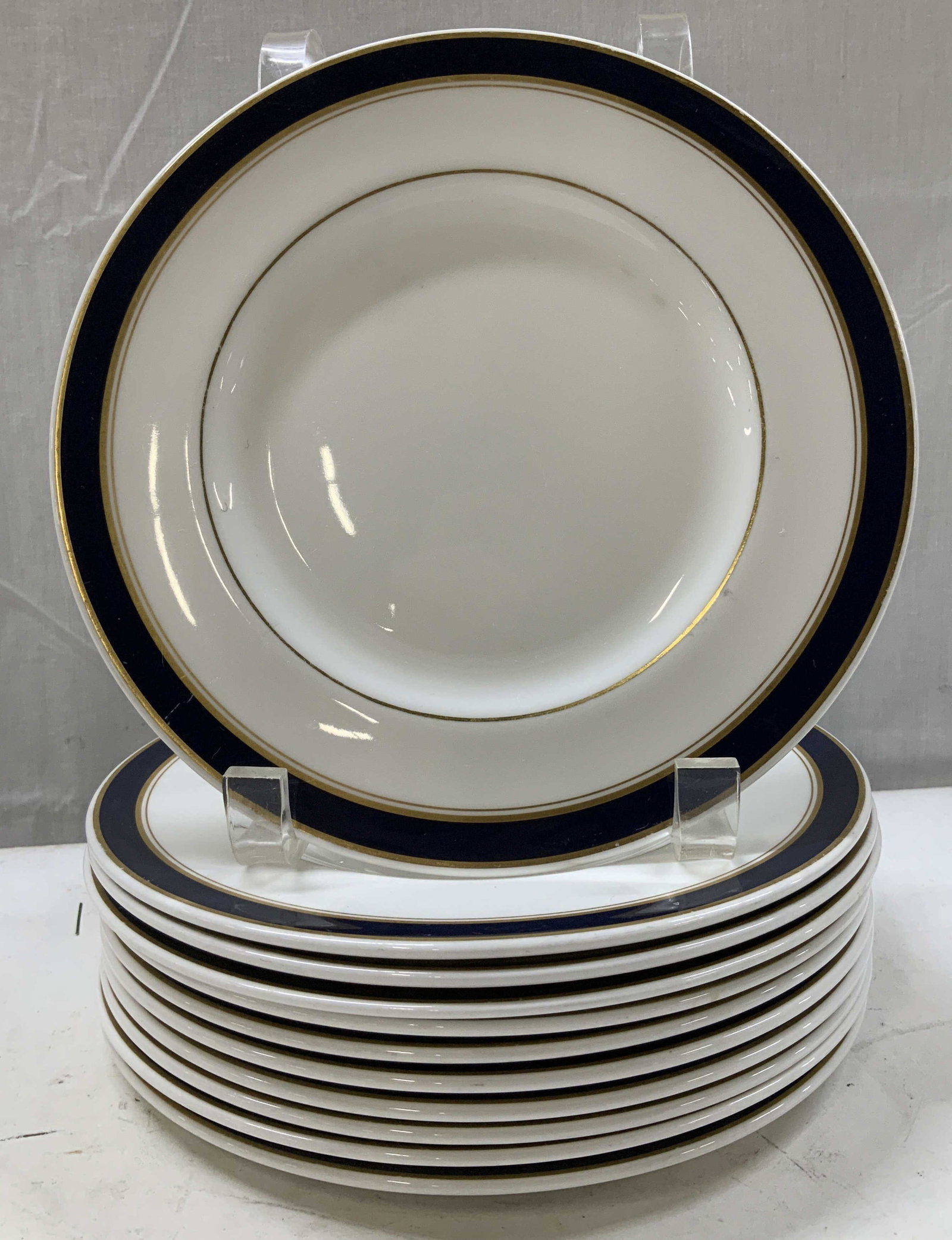 Set 11 Royal Doulton British Airways Plates ENG: Plates are bone china material & feature a blue band w gilt accents on both the other & inner edges of band. Signed & marked on underside. Reads, BRITISH AIRWAYS. MADE IN ENGLAND. ROYAL DOULTON. BONE