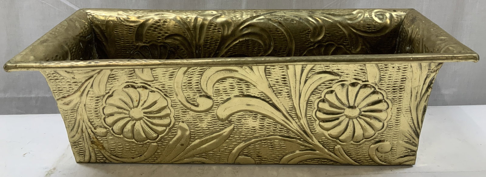Vntg Embossed Brass Floral Motif Planter: Planter is brass material & features a rectangular shape. Embossed floral & leaf motifs throughout body of planter. Surface wear consistent to age, use & exposure. Measurements: length 18in x width 7.