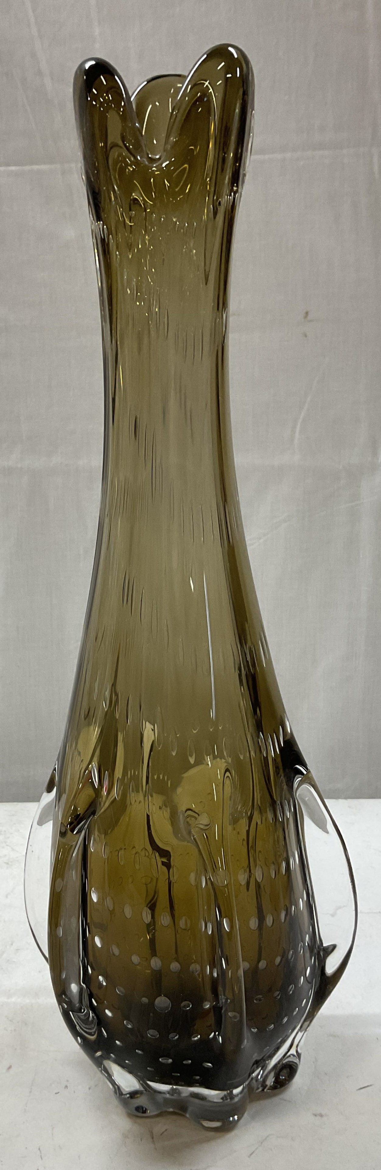 Hand Blown Amber Art Glass Vase: Hand blown amber art glass vase. Narrow flared trefoil top. Flares towards bottom. Air bubbles within glass. Dense and faceted base. Measures ht approx 16 inches base diameter approx 3 1/2 inches. Som
