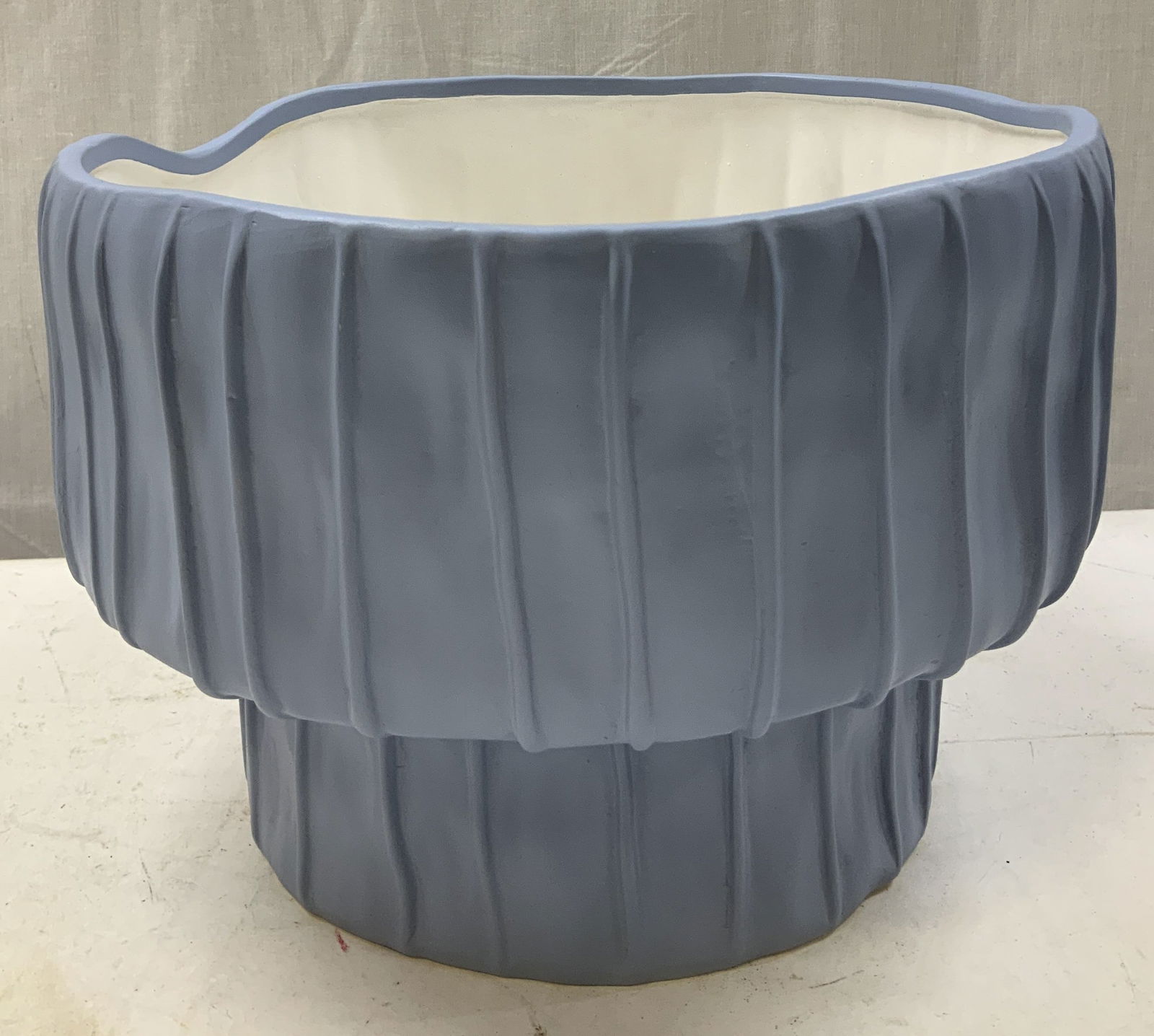 Tozai Home Blue Ribbed Ceramic Pedestal Bowl: Large ceramic pedestal bowl features a ribbed exterior & matte blue finish. Pedestal base & irregular top rim. Signed & marked on underside. Reads, TOZAI HOME. Surface wear consistent to age, use & ex