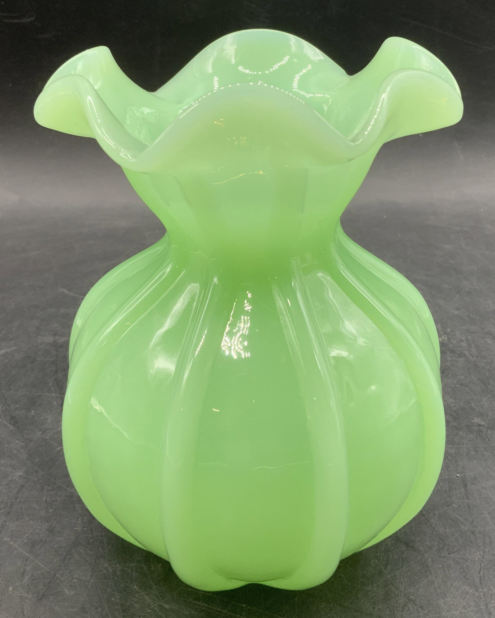 Hand Blown Green Art Glass Ruffled Vase: Light green art glass vase features a bulbous ribbed body & flared ruffled rim. Hand-blown Art glass vase. Surface wear consistent to age, use & exposure. Measurements: length 4.2in x width 4.2in x he