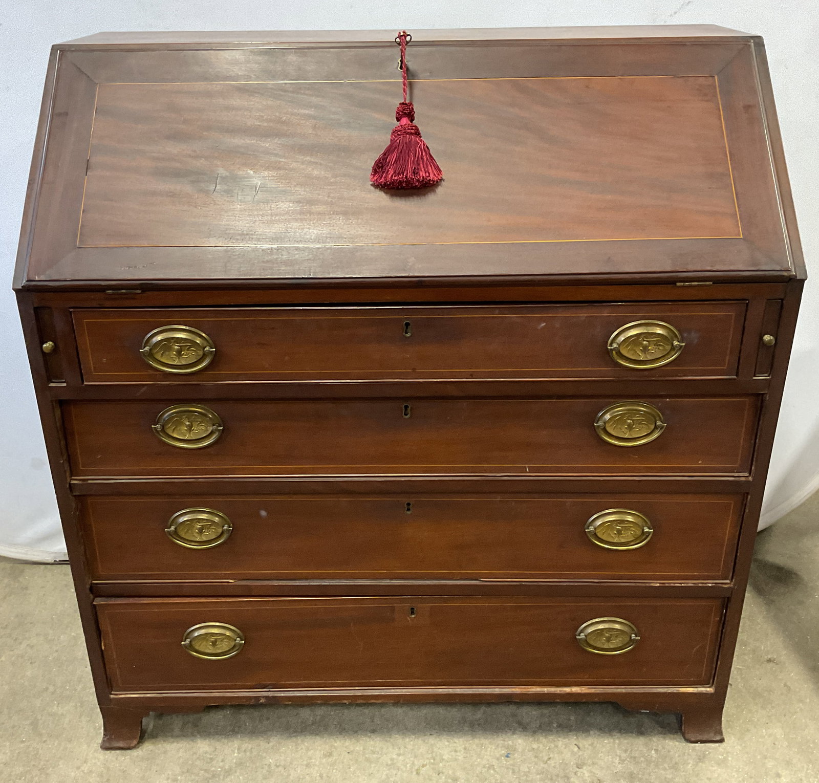 George III Style Mahogany Slant Front Desk: George III style mahogany slant front desk. Desk opens and contains multiple drawers and storage compartments. Two side desk supports pull out. Lower chest with 4 drawers. Brass hardware and handles. 