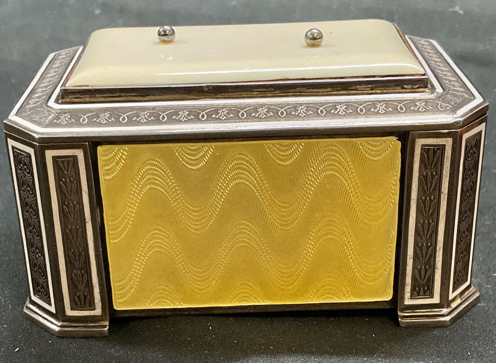 Art Deco 935 Silver Guilloche Enamel Jewelry Box: Vintage, possibly antique, English Art Deco jewelry box. 935 silver with yellow guilloche enameled panels. Gilt interior. Ornate scroll patterned frame. Signed with hallmarks on underside. Marked 935