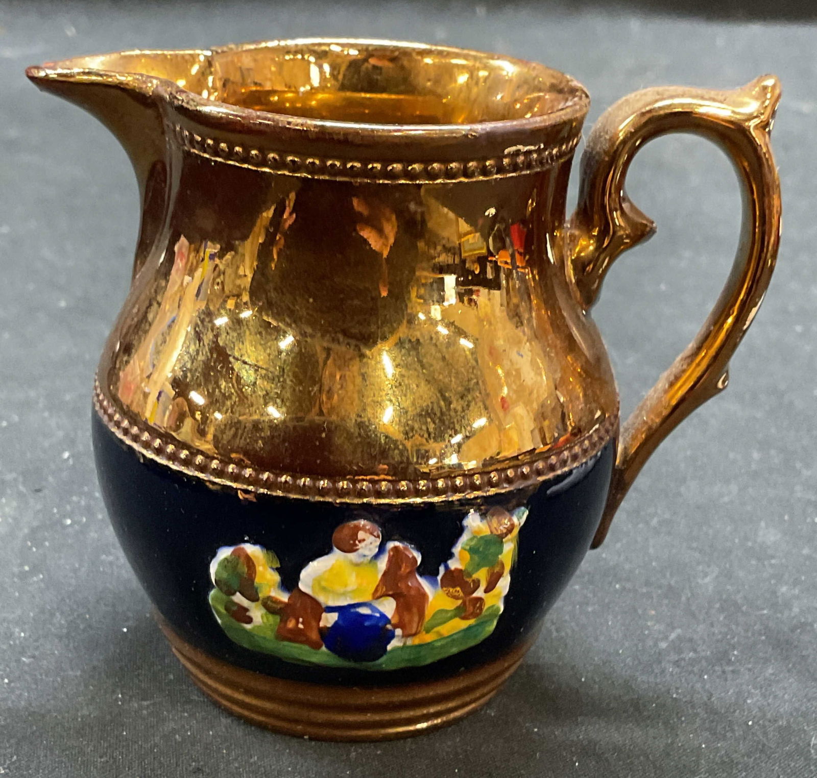 Antq English Victorian Copper Lusterware Creamer: Unsigned, appears to be Allertons Lontong English Victorian circa early 1800s. Antique Victorian style ceramic Lusterware creamer. Copper with blue band and raised figure motif. Hand painted. Measures