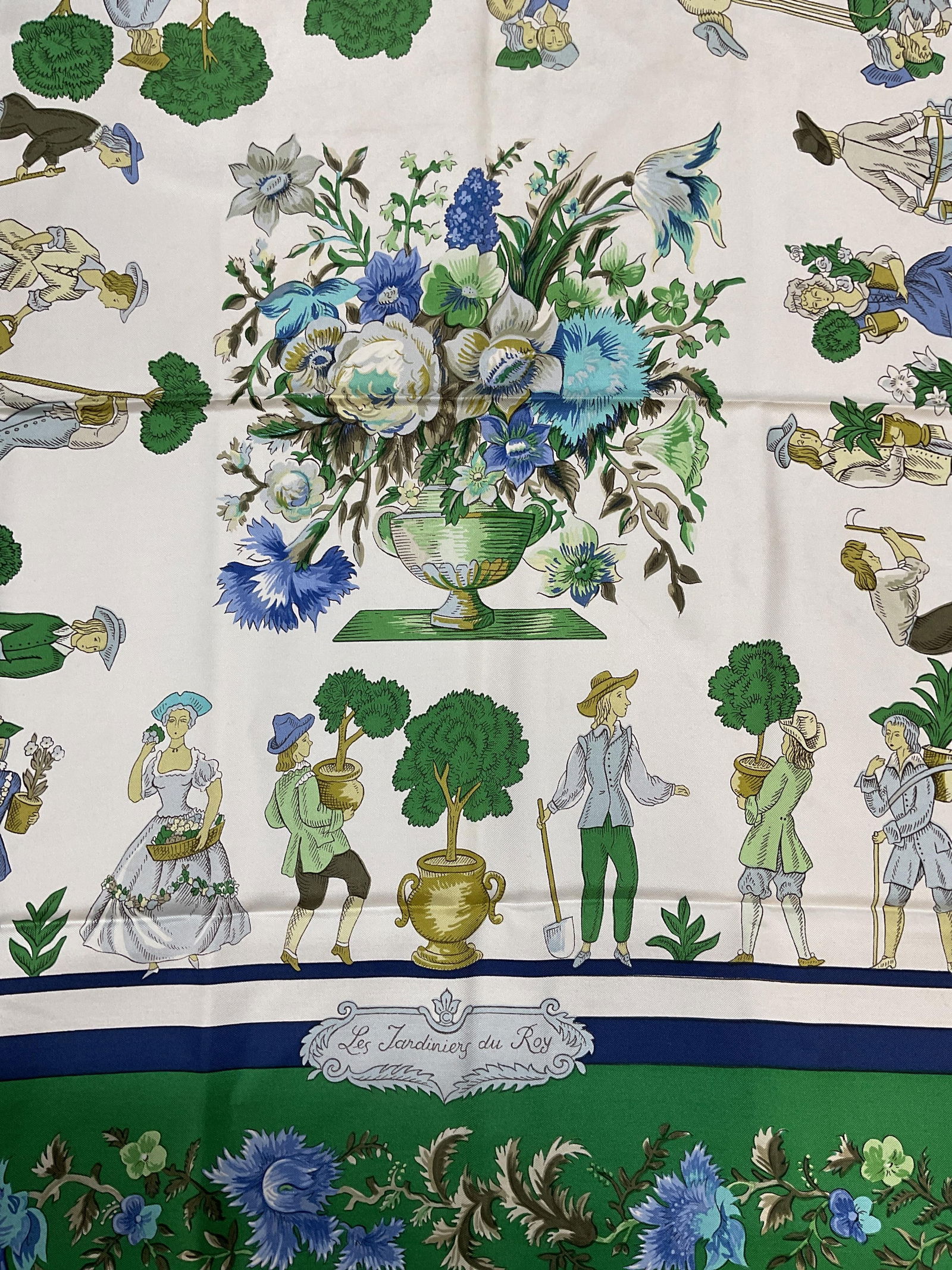 Hermes Jardiniers Du Roy Silk Scarf, France: Hermes silk scarf. Les jardiniers du Roy by Maurice Tranchant. Pastoral figures and flowers in blue and green. Hand rolled edges. Signed. Made in France. Measures approx 34 x 34 inches. Some blemishes