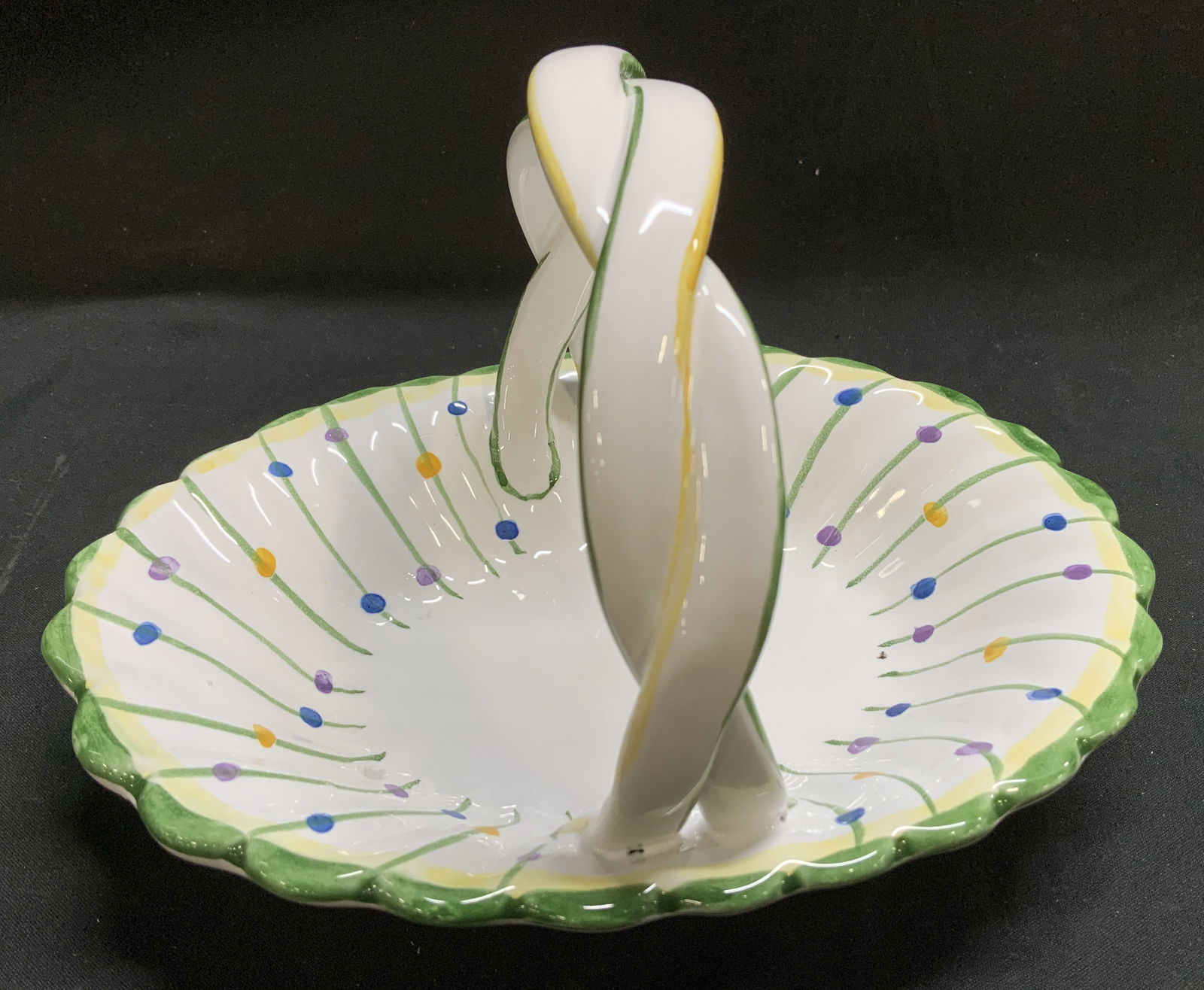 R.C. & CAL. Hand Painted Ceramic Basket PORTUGAL: Hand-painted ceramic basket with a braided handle & scalloped rim. Features multi-colored polka dots. Glossy finish. Signed & marked on underside. Reads, R.C. & CAL. PORTO DE MOA. HAND PAINTED. MADE I