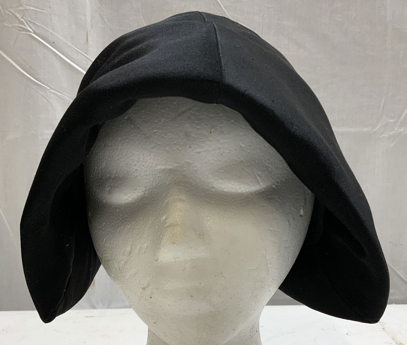 Bergdorf Goodman on the Plaza Black Hat: Hat features an asymmetrical sculptural design w two long pointed flaps. Round crown. Signed & marked. Reads, MADE TO ORDER HAT. BERGDORF. GOODMAN ON THE PLAZA, NEW YORK. Surface wear consistent to ag