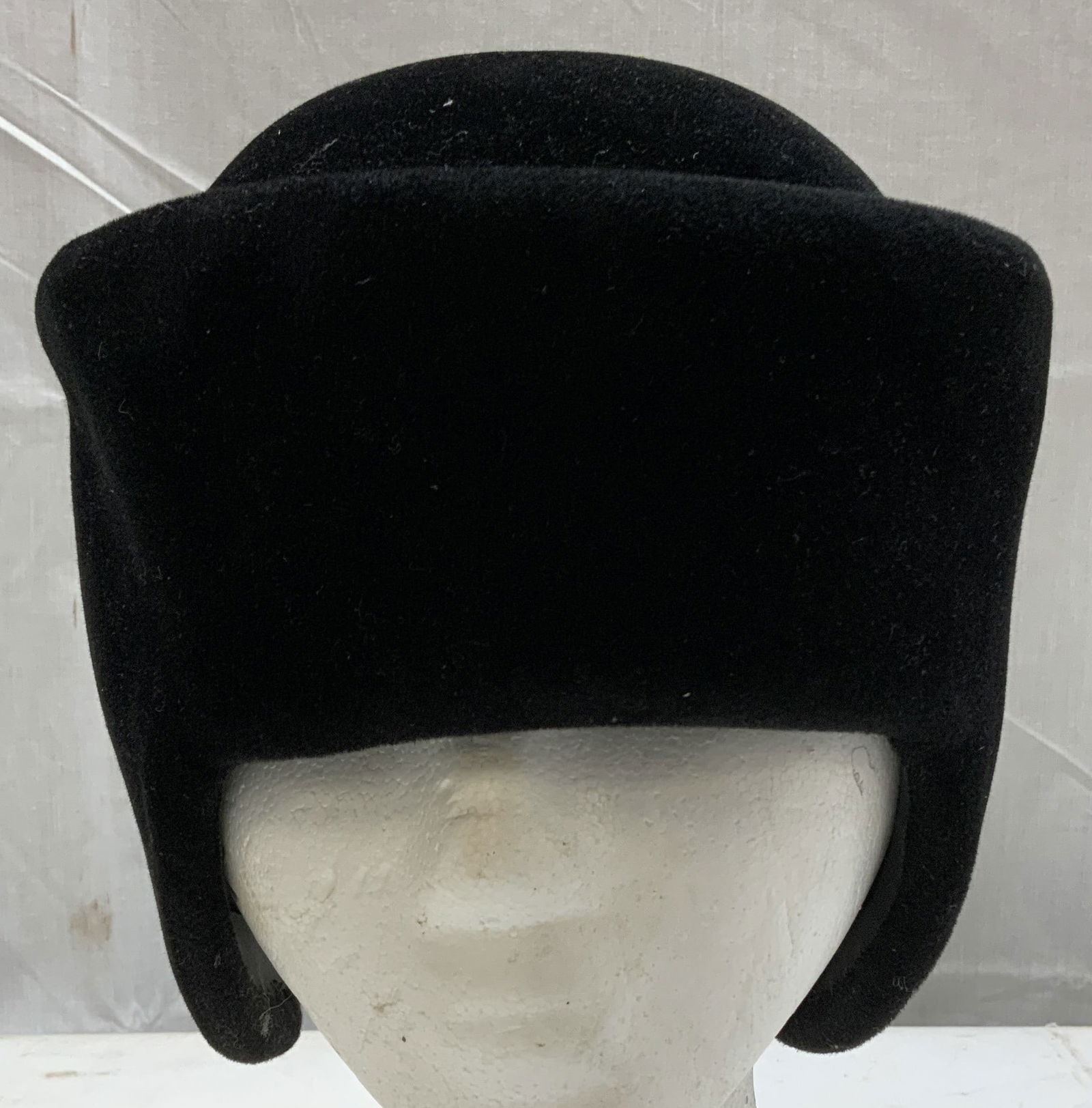 Bergdorf Goodman on the Plaza Pillbox Style Hat NY: Black velvet pillbox style hat w a tall rounded crown. Features two pointed ear flaps that hang down on each side. Signed & marked. Reads, MADE TO ORDER HAT. BERGDORF GOODMAN ON THE PLAZA. NEW YORK. S