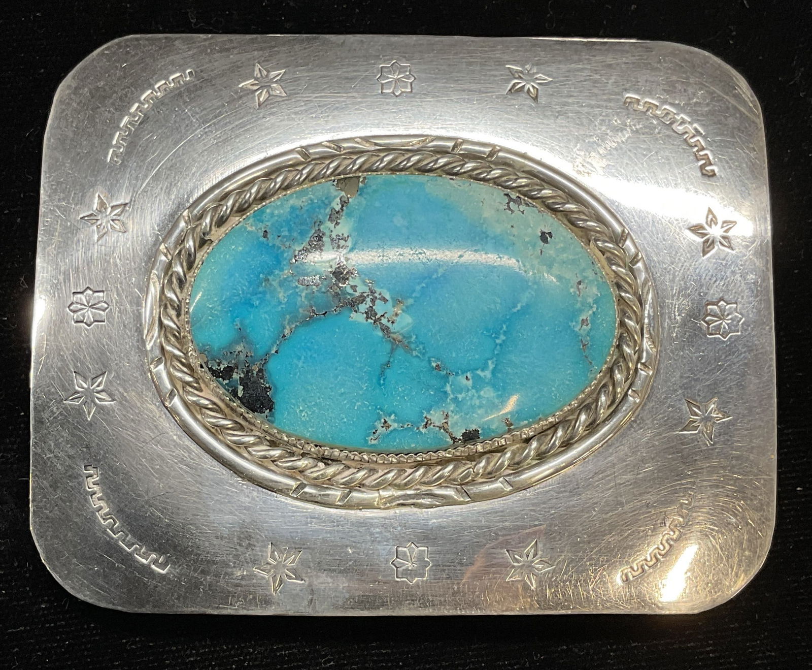 Sterling Silver Blue Cabochon Belt Buckle: Sterling silver belt buckle with blue oval semiprecious stone cabochon. Stamped border design. Marked sterling. Measures approx 3.25 x 2.75 inches. Total weight 81.5 grams. Some scratching. Sterling s