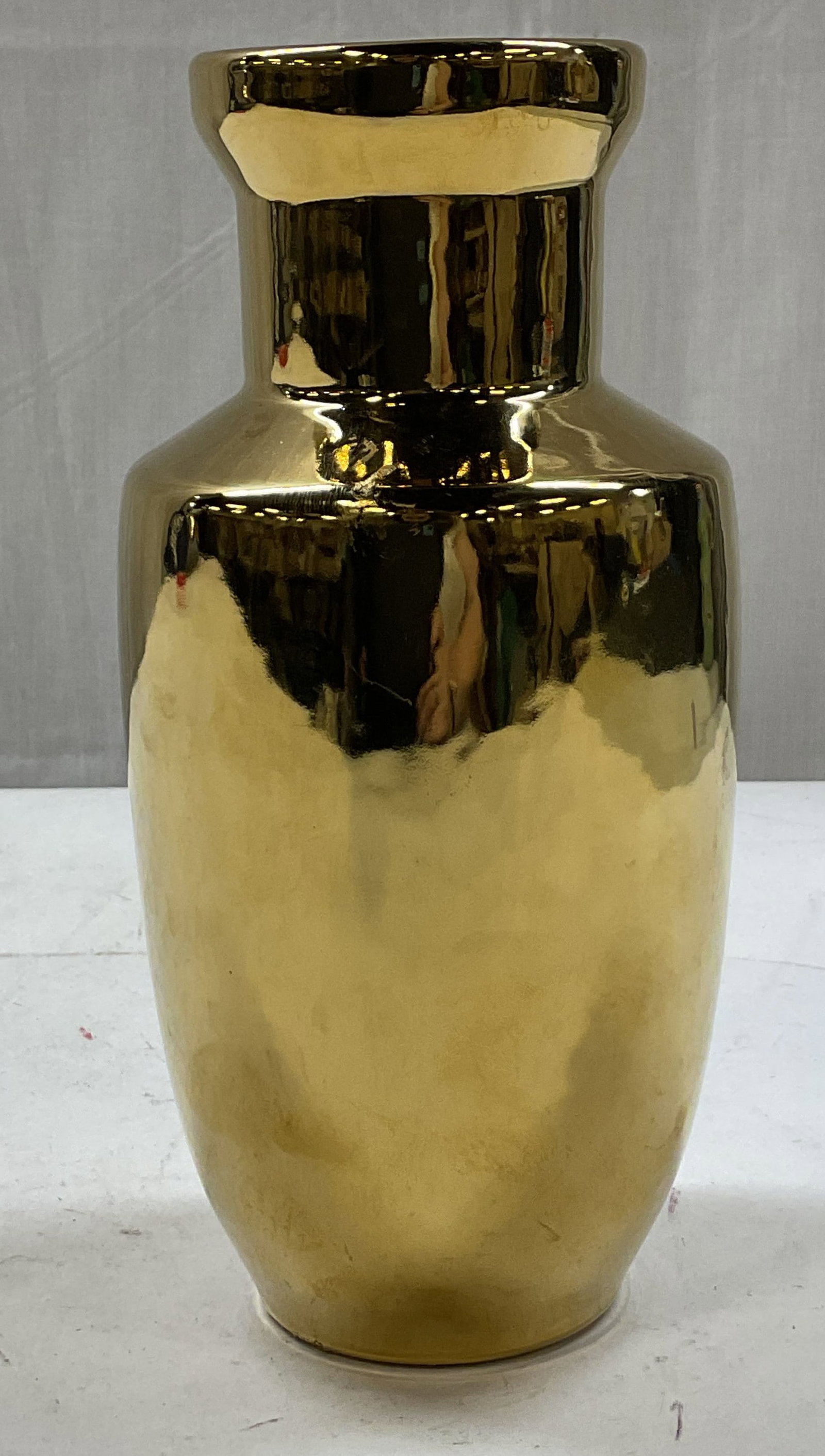 Tozai Home Gold Toned Decorative Vase: Tozai Home gold toned decorative vase. Polished brass. Flared rim and wide body. Measures ht approx 8 1/2 inches diam approx 3 inches. Some surface wear consistent with exposure. Some scratching obser