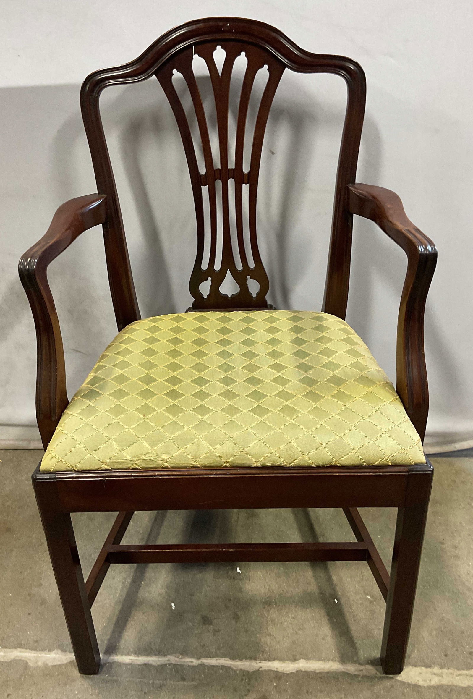 Vintage Mahogany Upholstered Armchair: Vintage mahogany armchair with decorative carved backrest and upholstered green fabric seat. Measures approx 22 x 17.5 x 37.5 inches. Splitting to backrest and scratching. Chair, vintage chair, mahoga