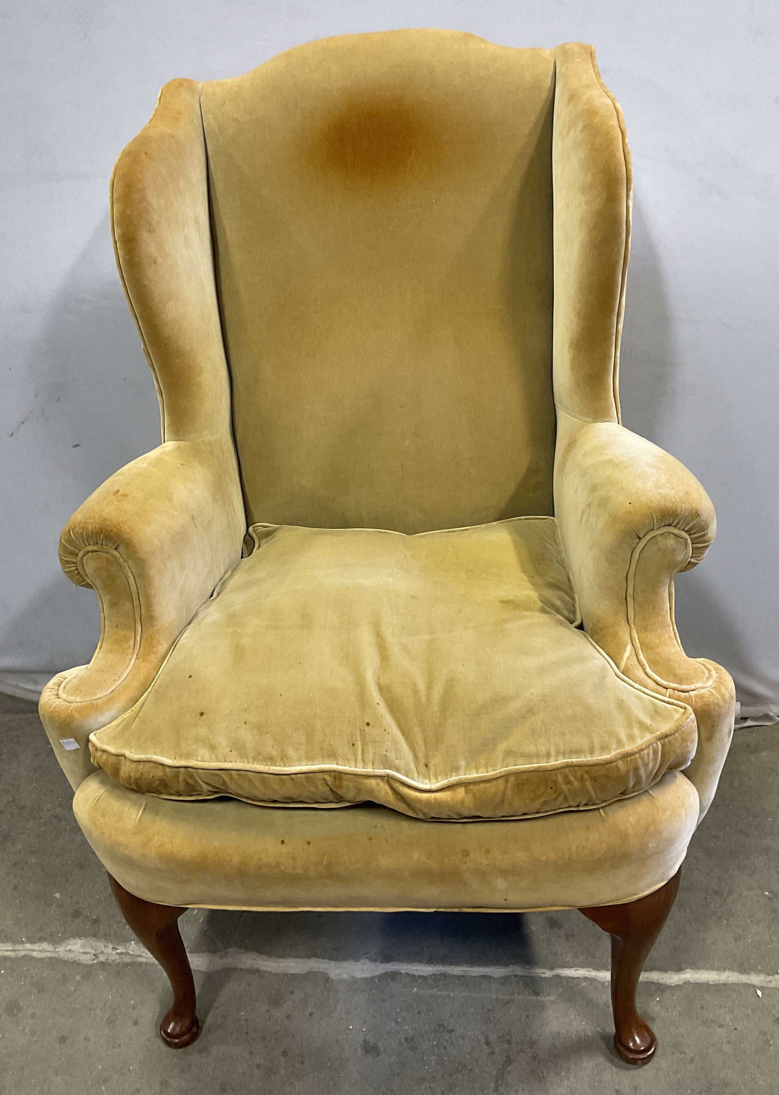 Vintage Wingback Green Velvet Armchair: Vintage wingback armchair. Green velvet upholstered with seat cushion. Measures approx 31 x 24 x 44.5 inches. Some scratching. Discoloration and blemishes to upholstery. Wingback chair, armchair, velv