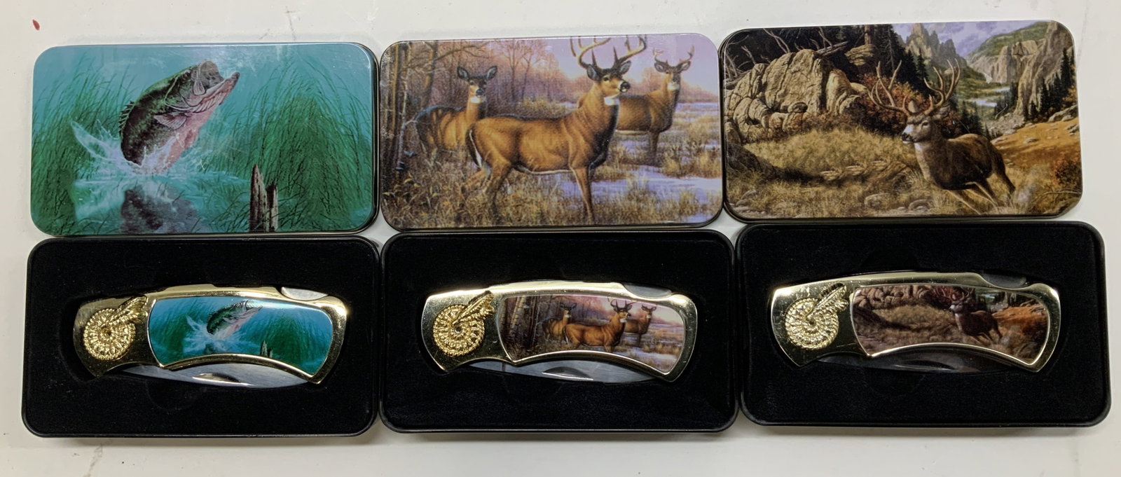 Lot 3 Deer & Fish Motif Stainless Pocket Knifes: Pocket knifes are stainless steel material & feature images of deer & fish motifs. Comes with original matching boxes. No visible signature or markings. Surface wear consistent to age, use & exposure.