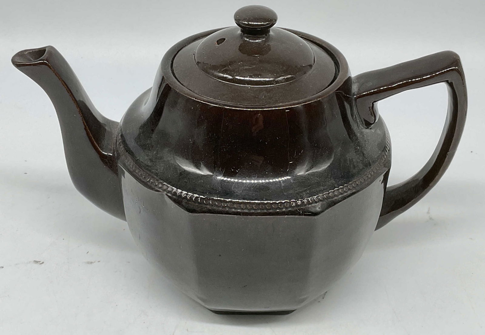 Brown Glazed Ceramic Teapot, England: Brown glazed ceramic teapot. Made in England. Measures approx 9 x 5.5 x 6.5 inches. Some wear consistent with exposure. Teapot, ceramic teapot, brown teapot, tableware, table accessories, homewares, h