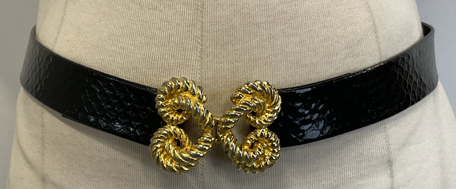 SGND Black Leather Belt & Gold Toned Buckle: Signed black leather belt and gold toned buckle. Buckle is signed illegibly dated 1974. Faux snakeskin texture. Decorative gold toned buckle that hooks. Measures approx 32 inches in length. Some wear 