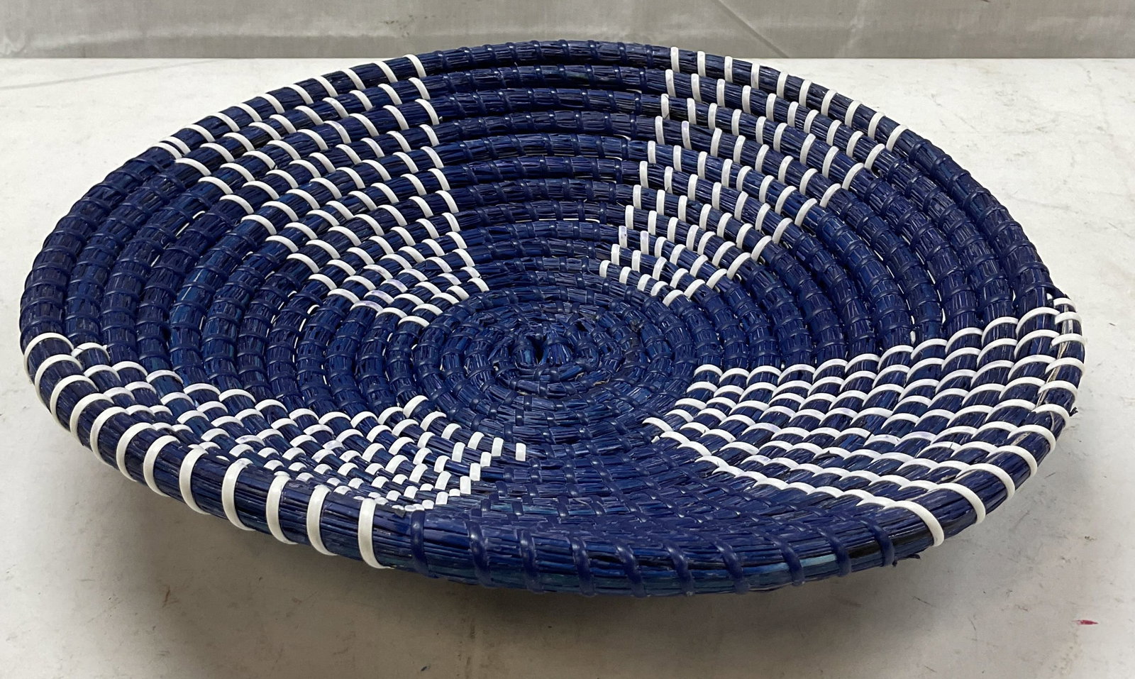 Vintage Blue & White Woven Basket: Vintage blue and white woven basket. Woven design in a blue and white pattern. Measures approx 13 1/2 inches in diameter. Surface wear consistent with exposure. Material is shedding. Basket, woven bas