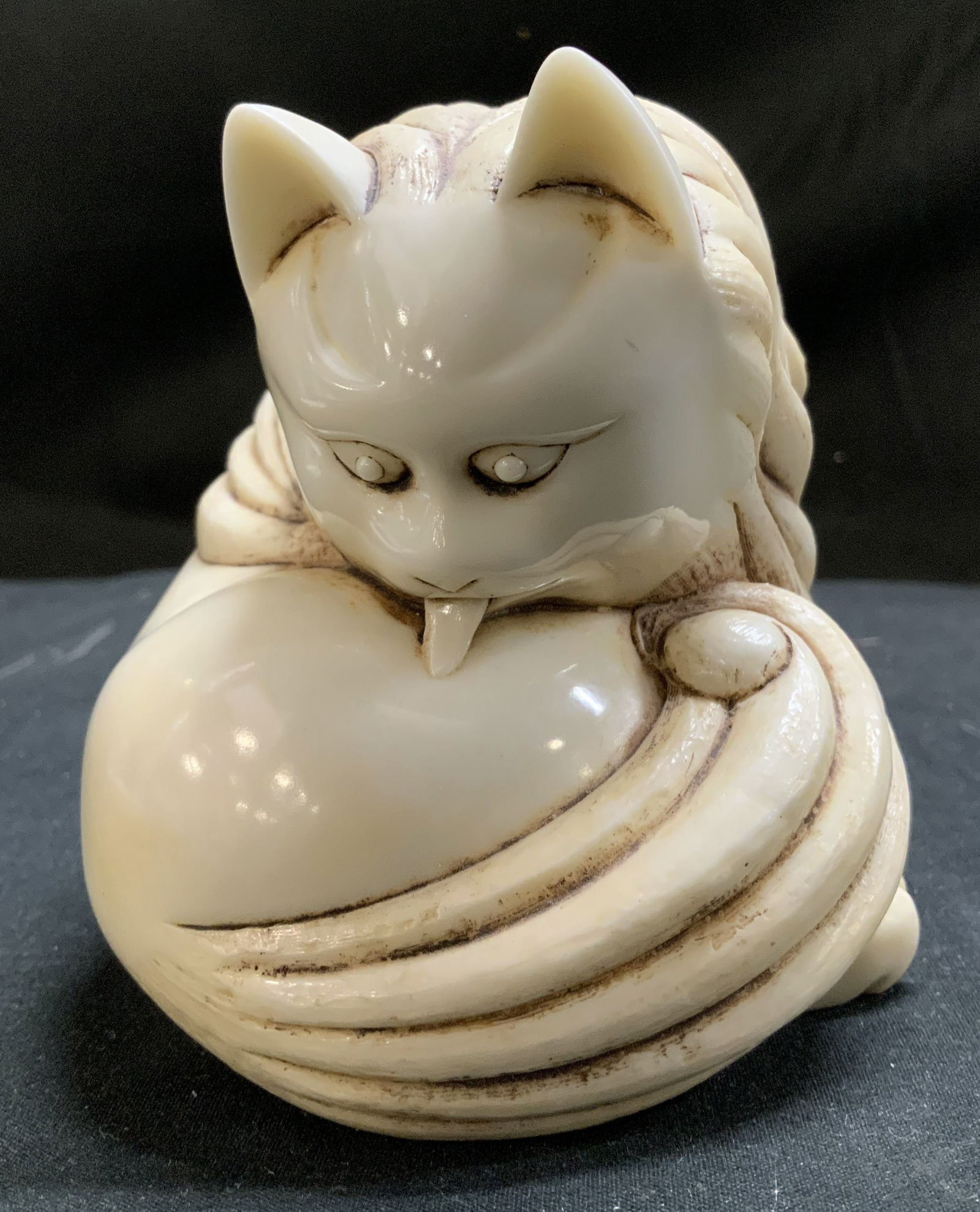 Ivory Tone Carved Resin Licking Cat Figurine: Figurine is resin & depicts a cat licking itself w carved/textured details. Ivory toned. Signed & marked on underside. Reads, MADE IN CHINA. Surface wear consistent to age, use & exposure. Measurement