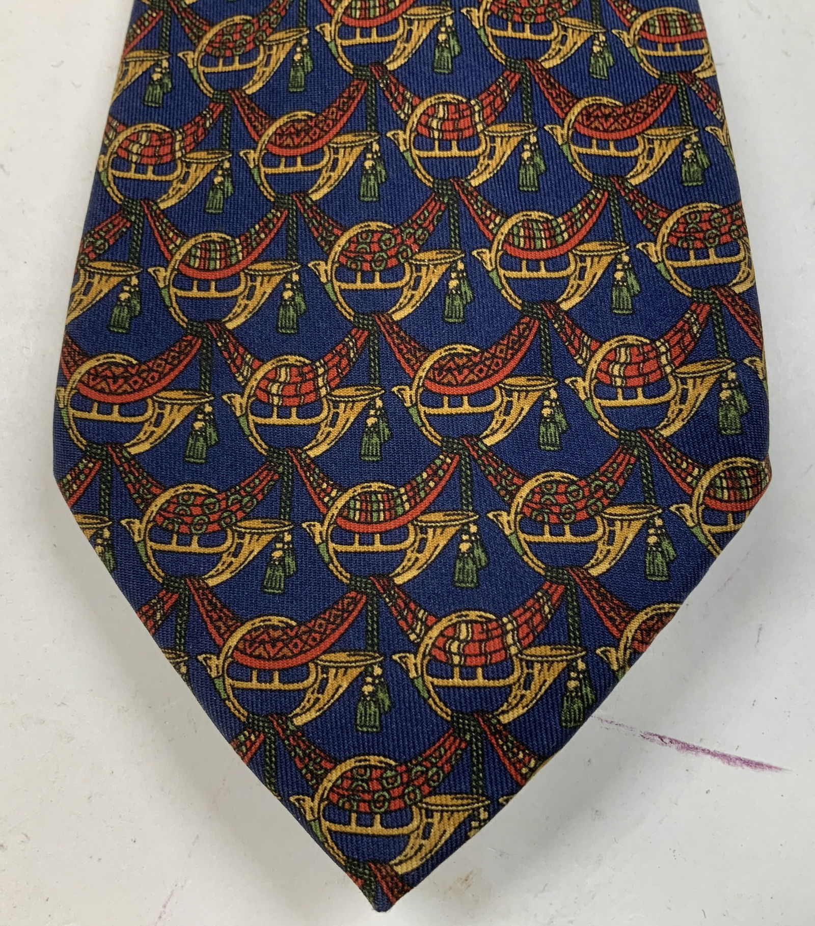 Salvatore Ferragamo Navy Silk Necktie ITALY: Necktie is 100% silk material & features a distinctive horn pattern. Shades of navy, red, green & yellow. Signed & marked. Reads, Salvatore Ferragamo. MADE IN ITALY. Surface wear consistent to age, us