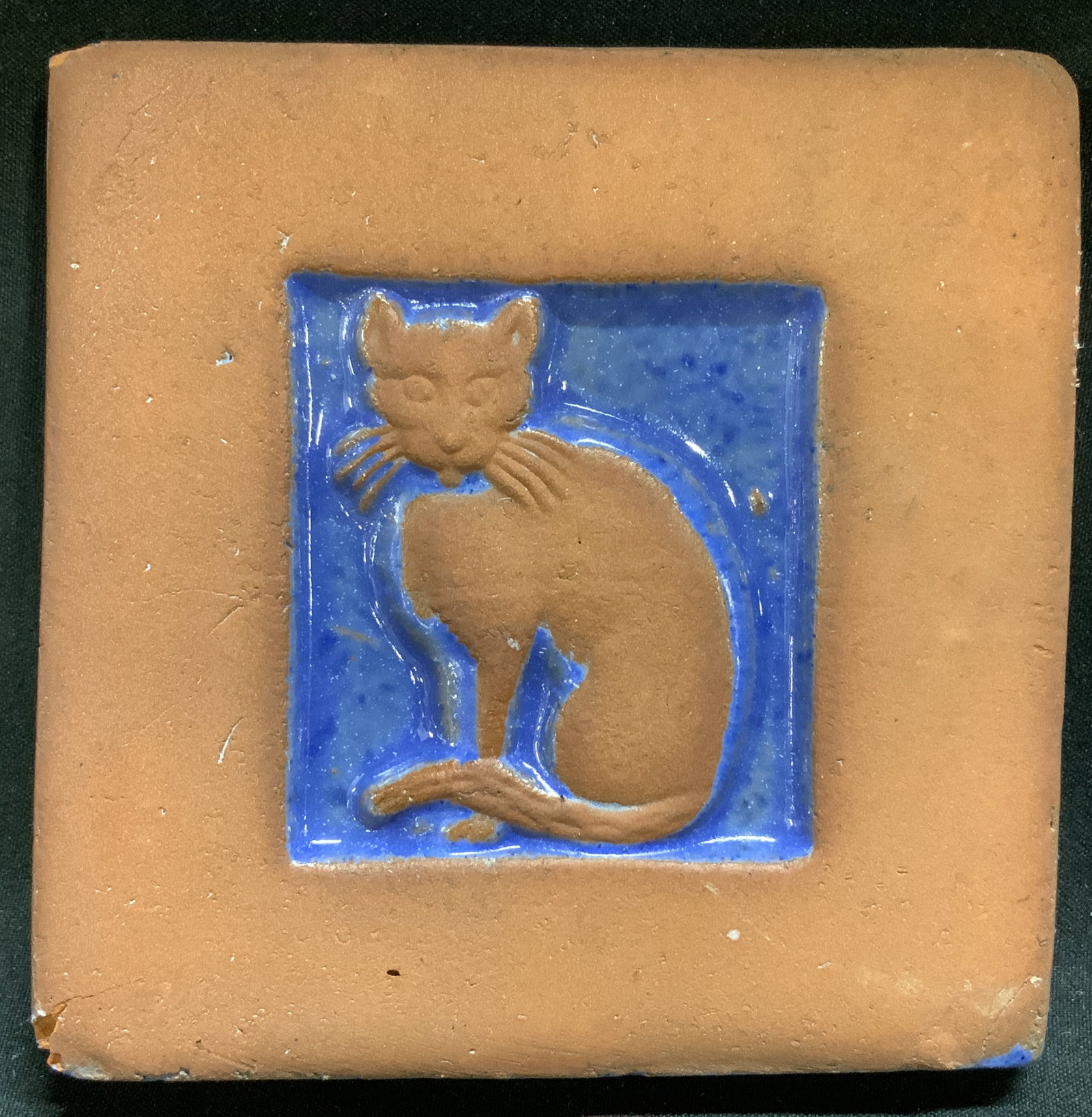 Sgnd 1997 Terracotta Blue Glaze Cat Tile: Tile appears to be terracotta material & features an impressed design of a cat w a blue glaze. Square shape. Signed & marked on underside. Reads, 1997. Visible marking, not legible. Surface wear consi