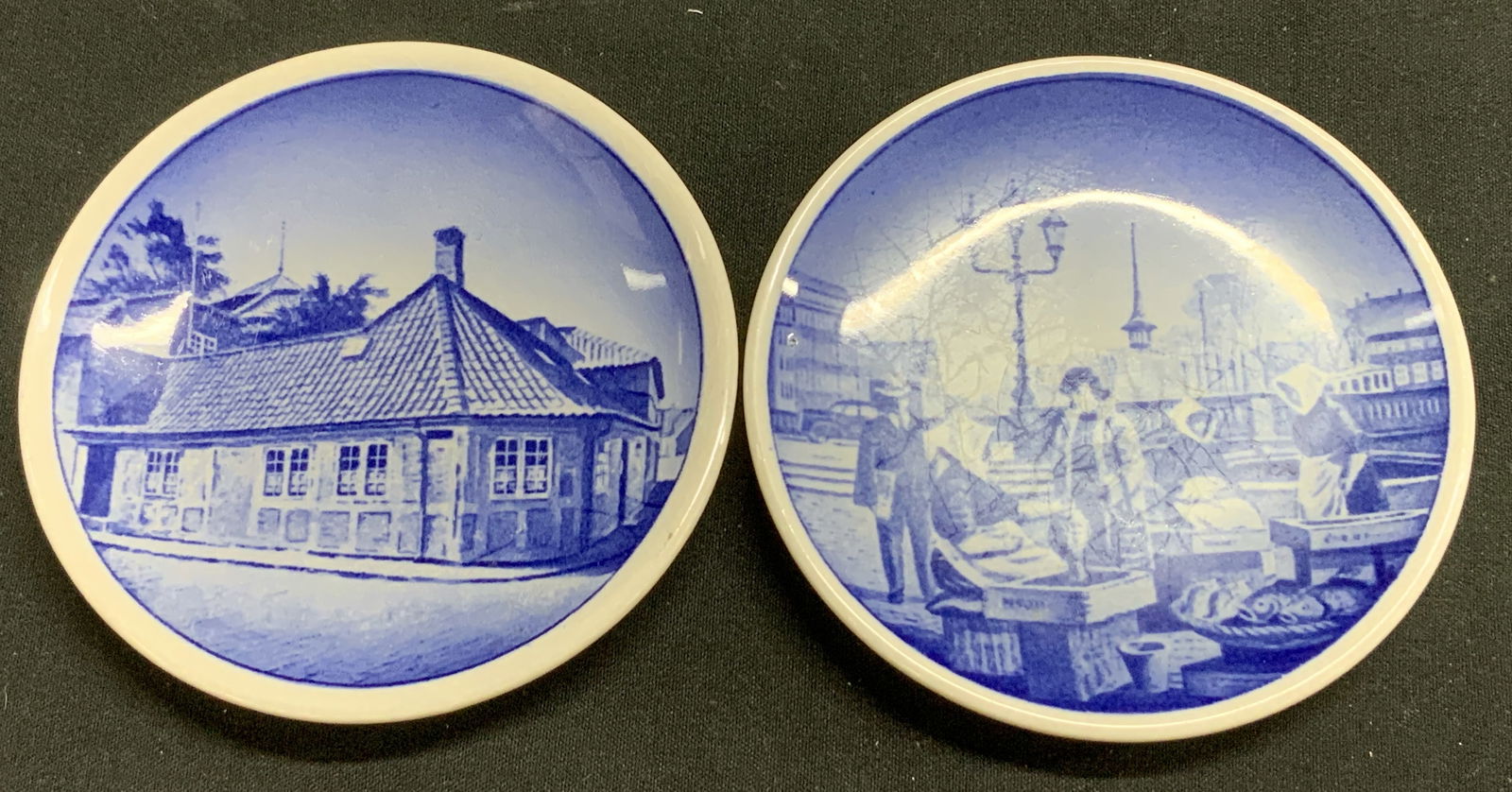 Pair Royal Copenhagen Scenic Trnkt Dish DENMARK: Lot includes, 2 round trinket dishes feathering a Dutch scenic design. Blue & white tones. Signed & marked on underside. Reads, DENMARK. FISKETORVET GAMMEL STRAND K?BENHAVN & H.C. ANDERSENS HUS ODENSE