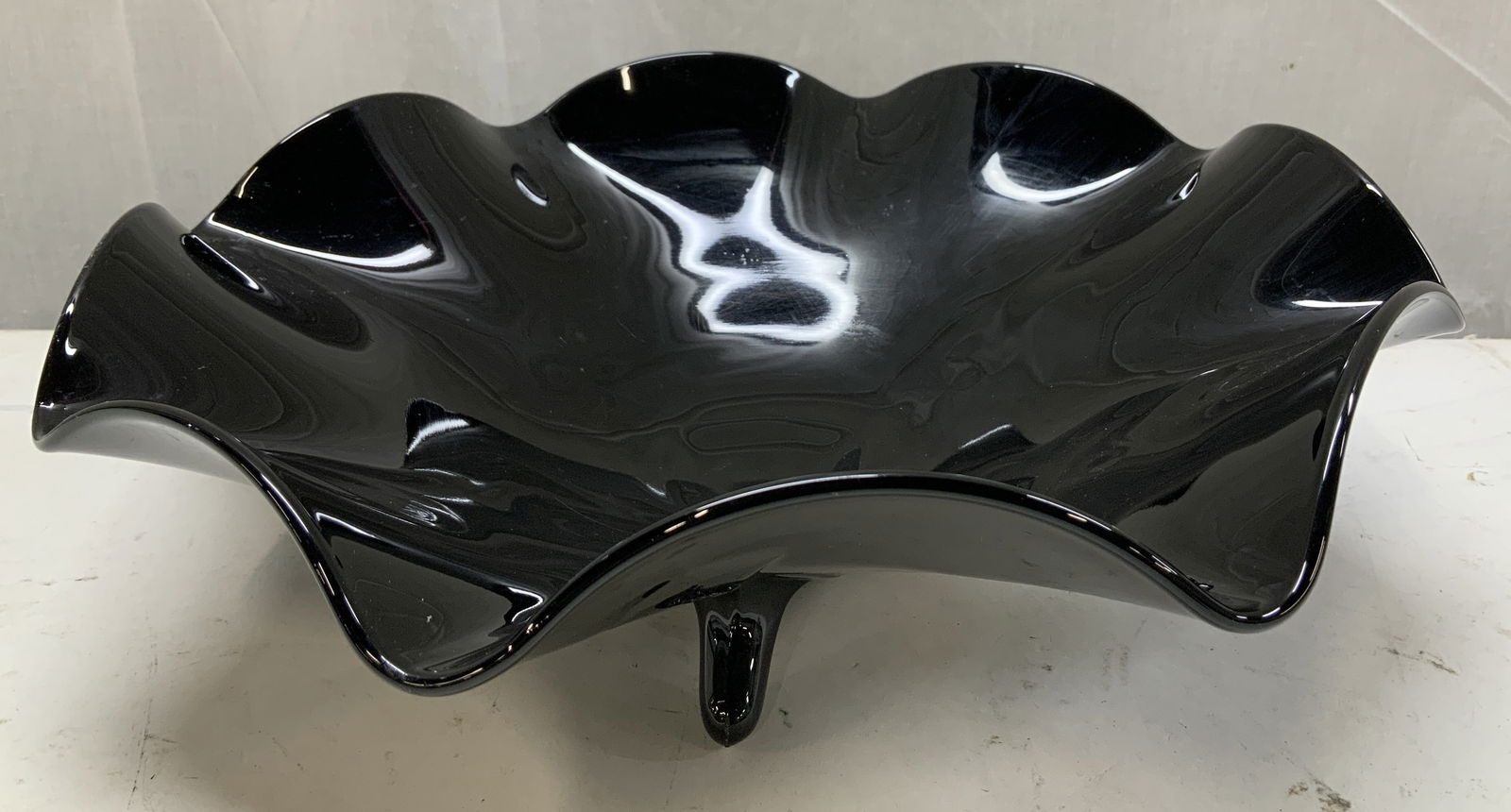 Vntg Black Glass Ruffled Footed Bowl: Footed bowl features a distinctive ruffled edge & 3 small feet. Piece is black glass. Possible L.E. Smith Mt. Pleasant. No visible signature or markings. Surface wear consistent to age, use & exposure