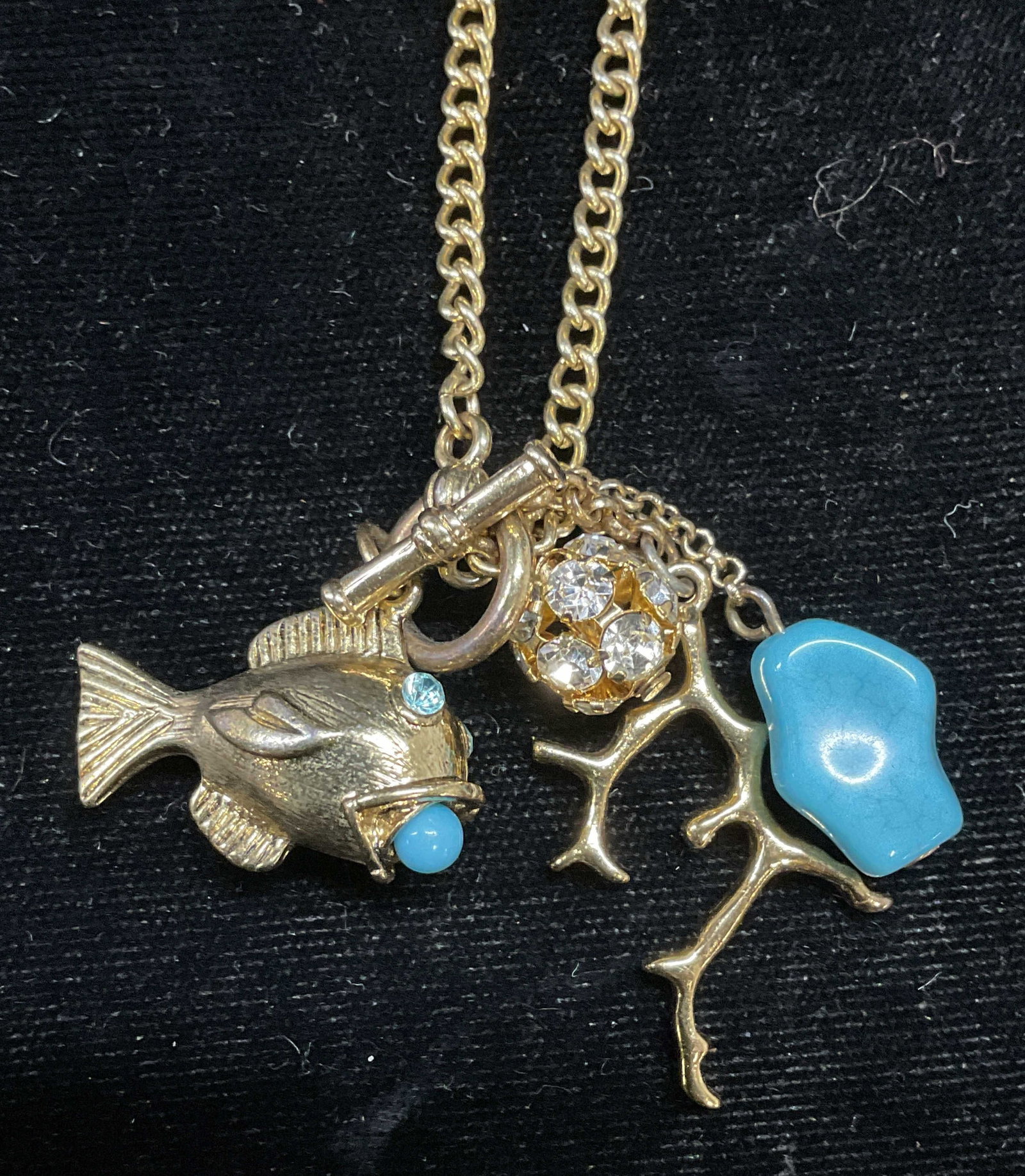 Gold Tone Faux Turquoise Pendant Necklace: Gold tone pendant necklace with faux turquoise and crystals. Fish and coral motif pendants. Drop length approx 8.5 inches. Some scratching. Jewelry, estate jewelry, costume jewelry, cocktail jewelry, 