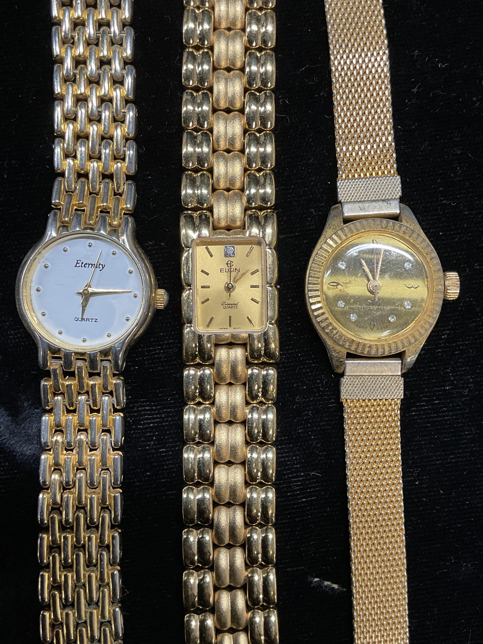 Lot 3 Elgin, Eternity + Gold Tone Wristwatches: Lot of 3 gold tone wristwatches. Signed Elgin, Eternity, and 1 illegible signed watch. Largest case measures approx 1 inch wide. Not tested. One band needs repair. Some scratching. Jewelry, estate jew