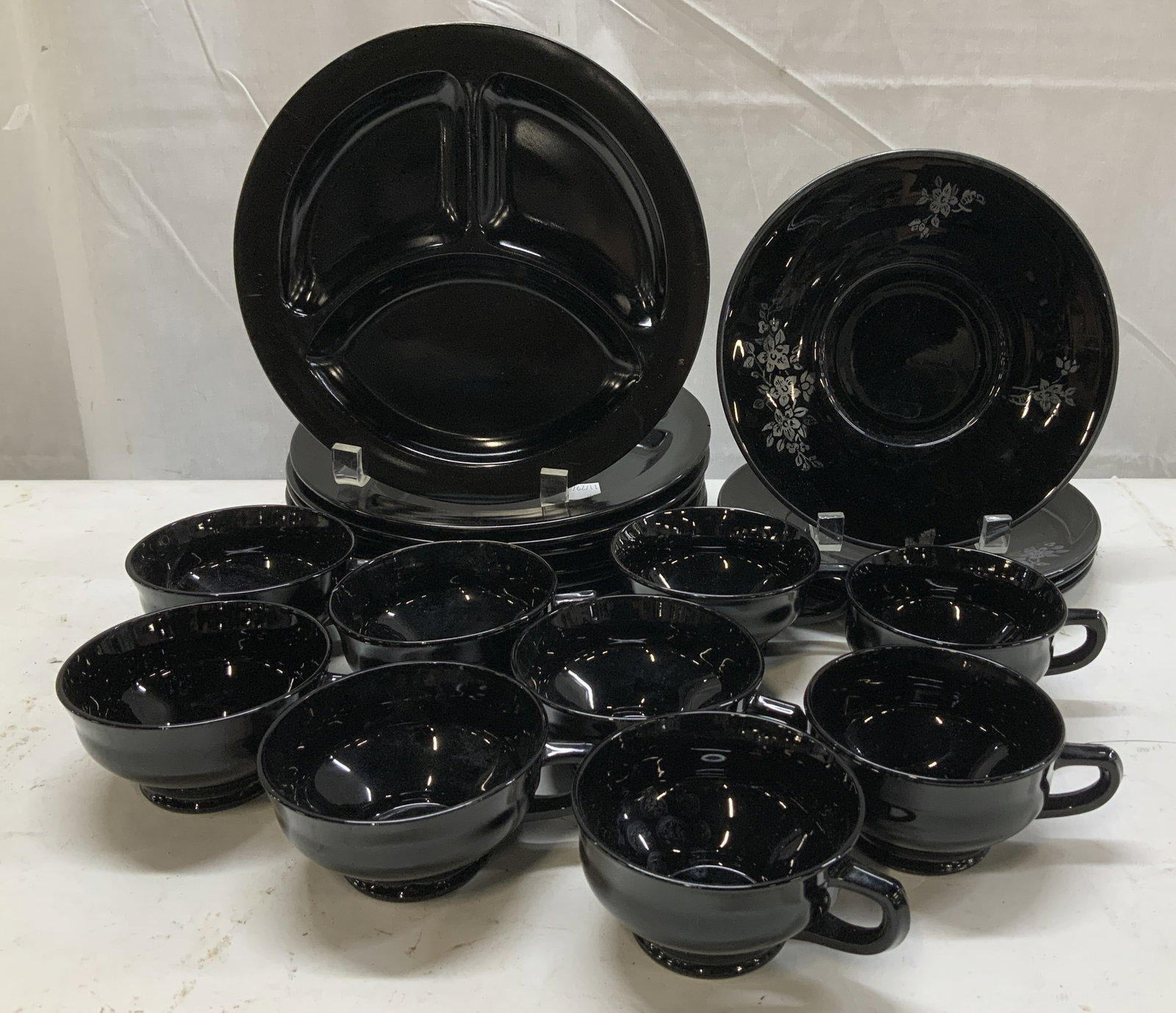 Lot 20 Black Glass Luncheon Plates, Salad & Cups: Cup Cups Lot includes, 4 floral salad plates, 9 teacups & 7 luncheon plates. Pieces are black glass & feature a glossy finish. Appears to be possible, L.E. Smith. No visible signature or markings. Mea