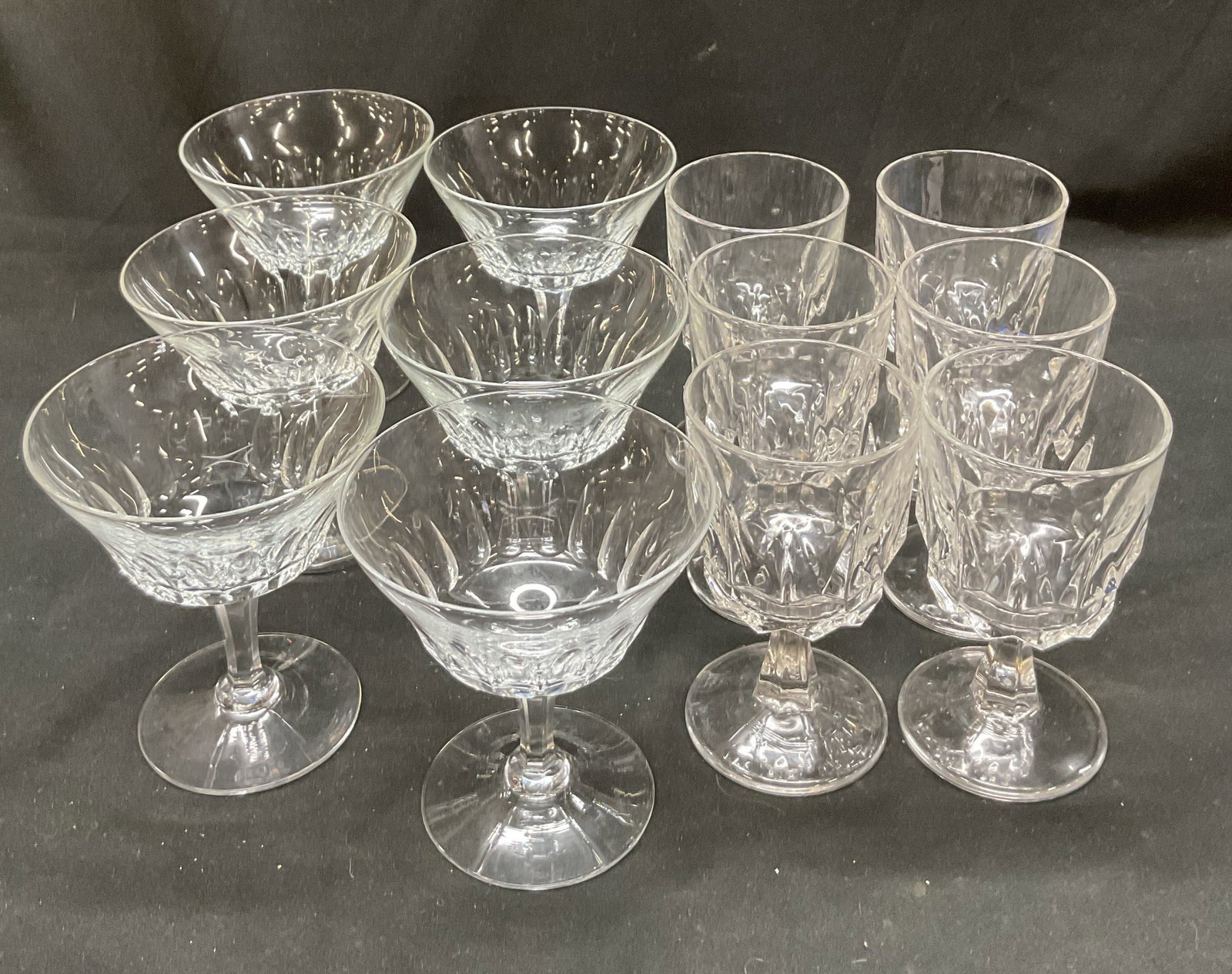 Set 12 Geometric Design Glass Stemware: 12 piece glass stemware set. Includes 6 champagne glasses and 6 wine glasses. Geometric designs and pedestal bases. Largest piece measures ht approx 4 1/2 inches base diameter approx 3 inches. Surface