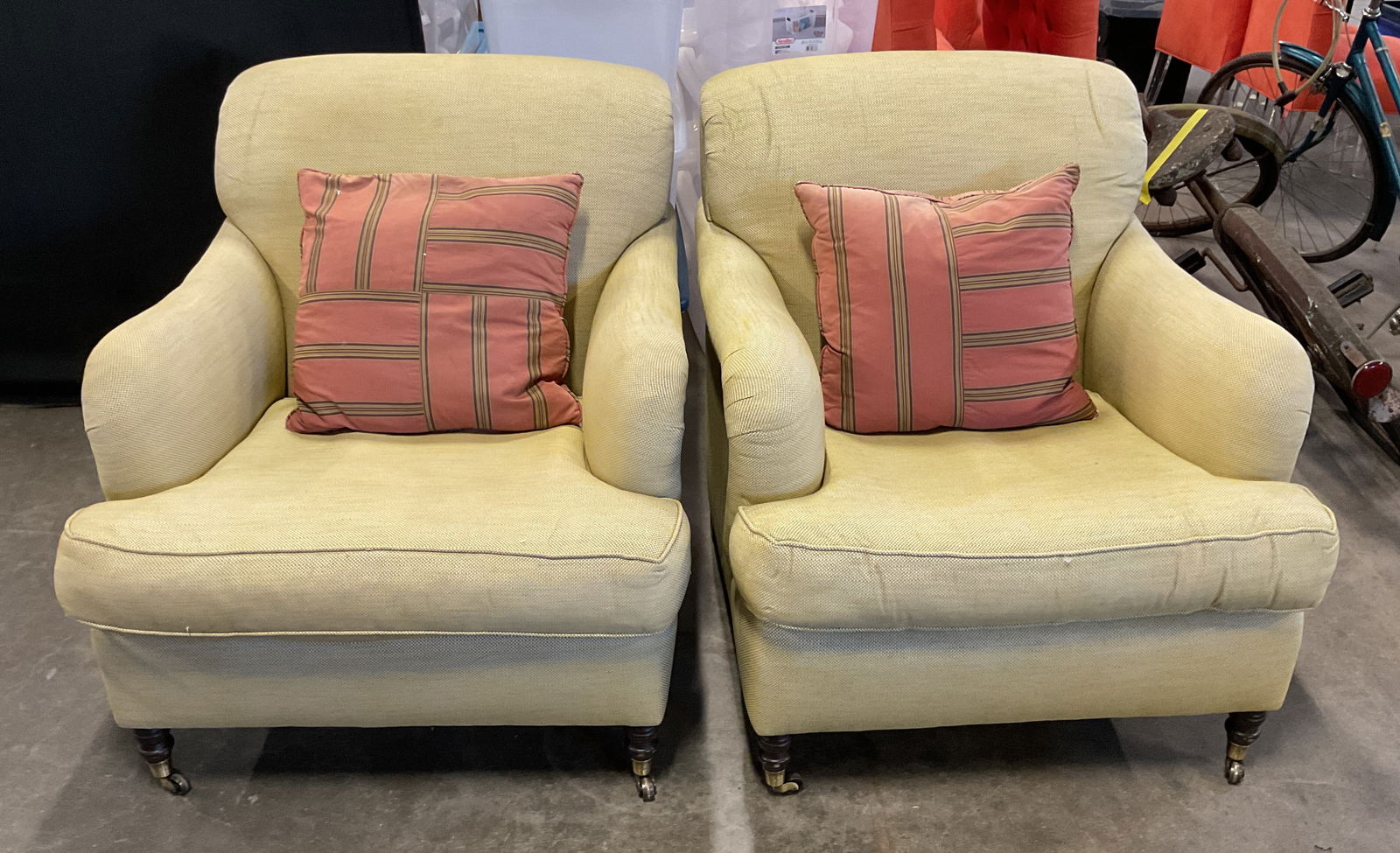 Pair Vtg Beige Upholstered Club Chairs & Pillows: Pair of vintage beige upholstered club chair armchairs with wheeled legs, includes red striped throw pillows. Chairs measure approx 32 x 36 x 34 inches. Wear including blemishes and discoloration. Arm