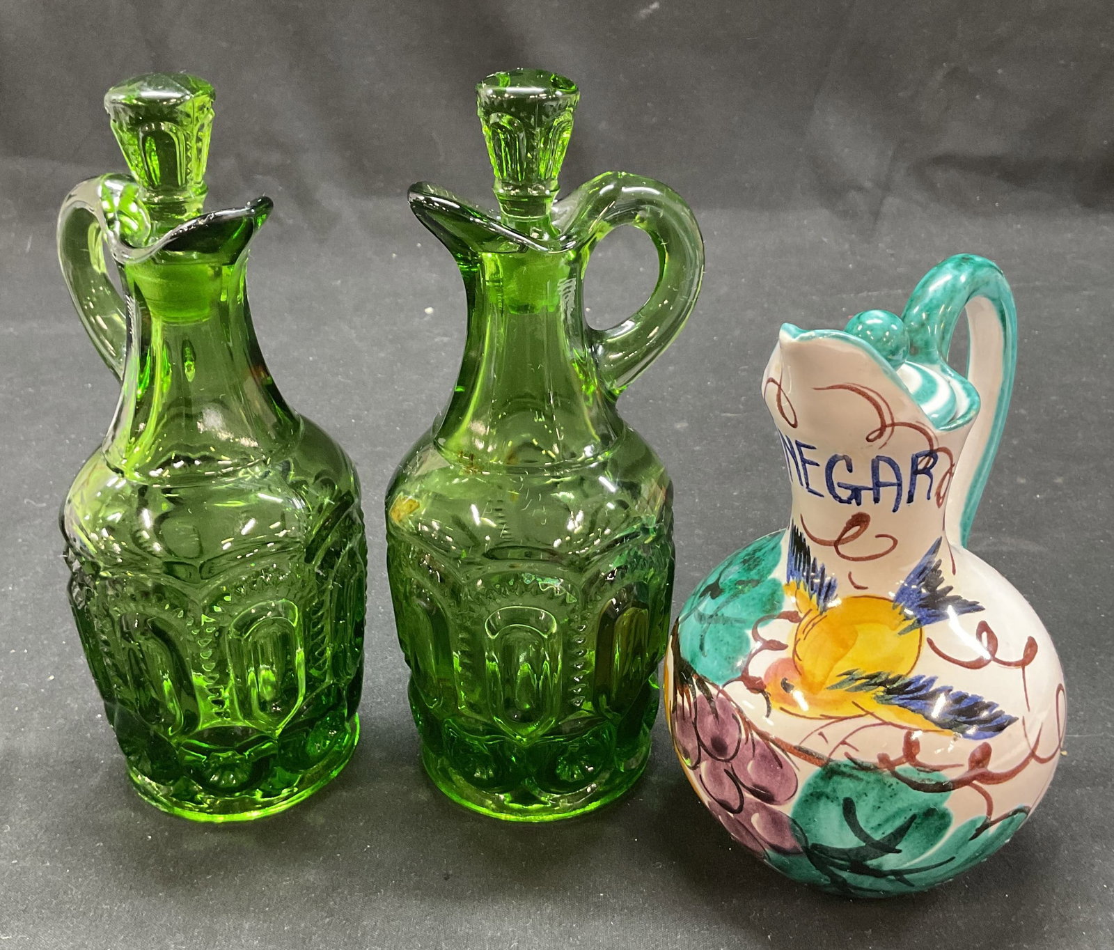 Lot 3 SGND Glass & Ceramic Cruet Italy: Lot of 3 glass and ceramic cruets with stoppers. Includes signed ceramic cruet. Made in Italy. Signed and marked on underside, signature illegible reads Italy. Hand painted bird, leaf, and grape motif