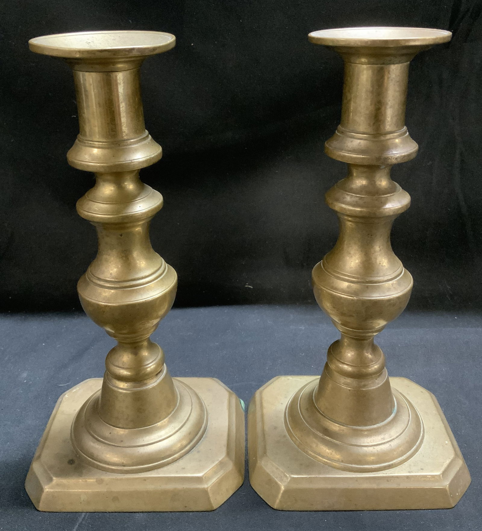 Vtg Pair Solid Brass Push Up Candlesticks: Candlesticks are brass material & feature a baluster stem. Square & clipped corner style base. Surface wear consistent to age, use & exposure. Measurements: length 3.7in x width 3.3in x height 7.3in.