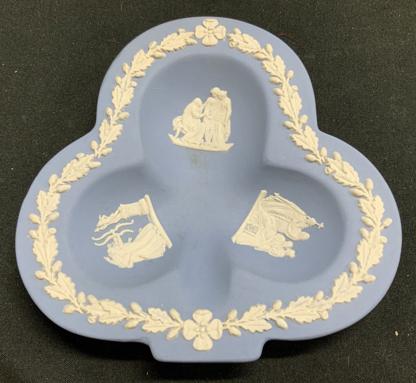 Wedgwood Blue Jasperware Ashtray ENGLAND: Vintage Wedgwood blue jasperware cloverleaf-shaped trinket dish. Features classic white relief Greek figures. Matte blue finish. Signed & marked. Reads, WEDGWOOD. MADE IN ENGLAND. Surface wear consist