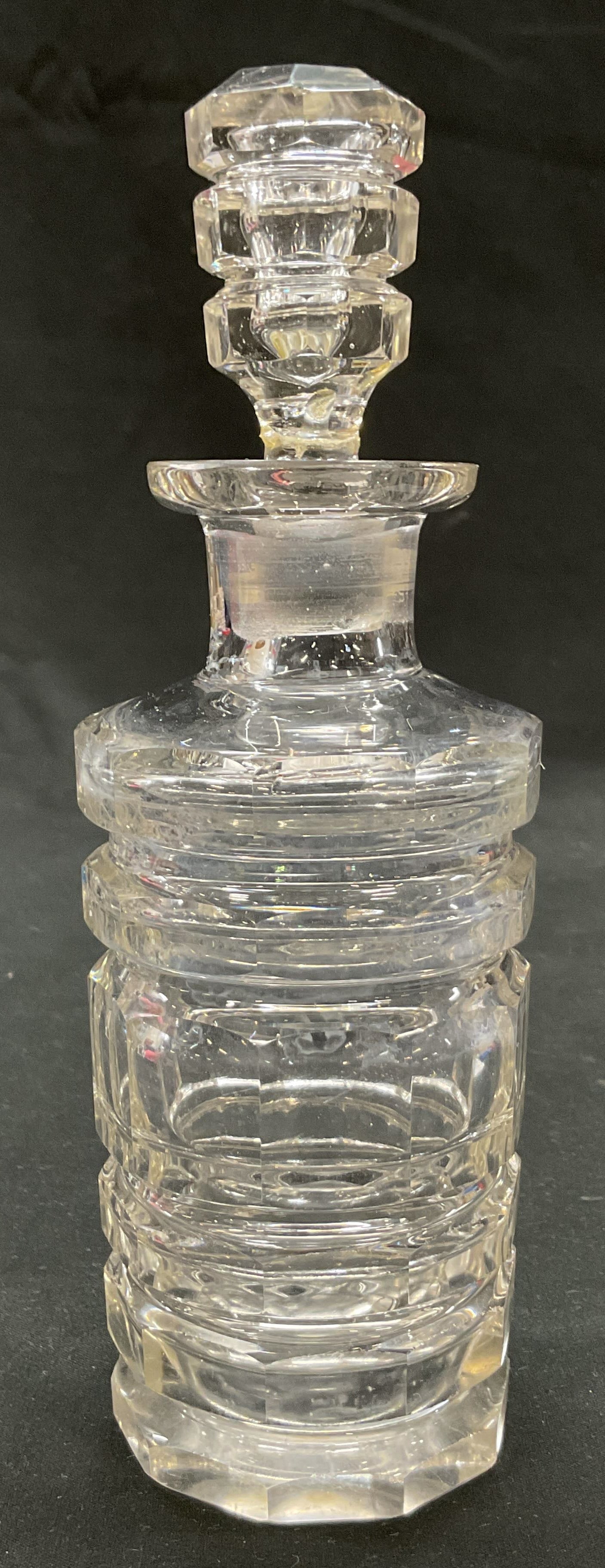 Vintage Cut Glass Cruet With Stopper: Vintage cut glass cruet with stopper. Cylinder shape. Faceted horizontal cuts. Same design on the stopper. Flat base. Measures ht approx 7 1/2 inches base diameter approx 2 1/2 inches. Rim chip on sto