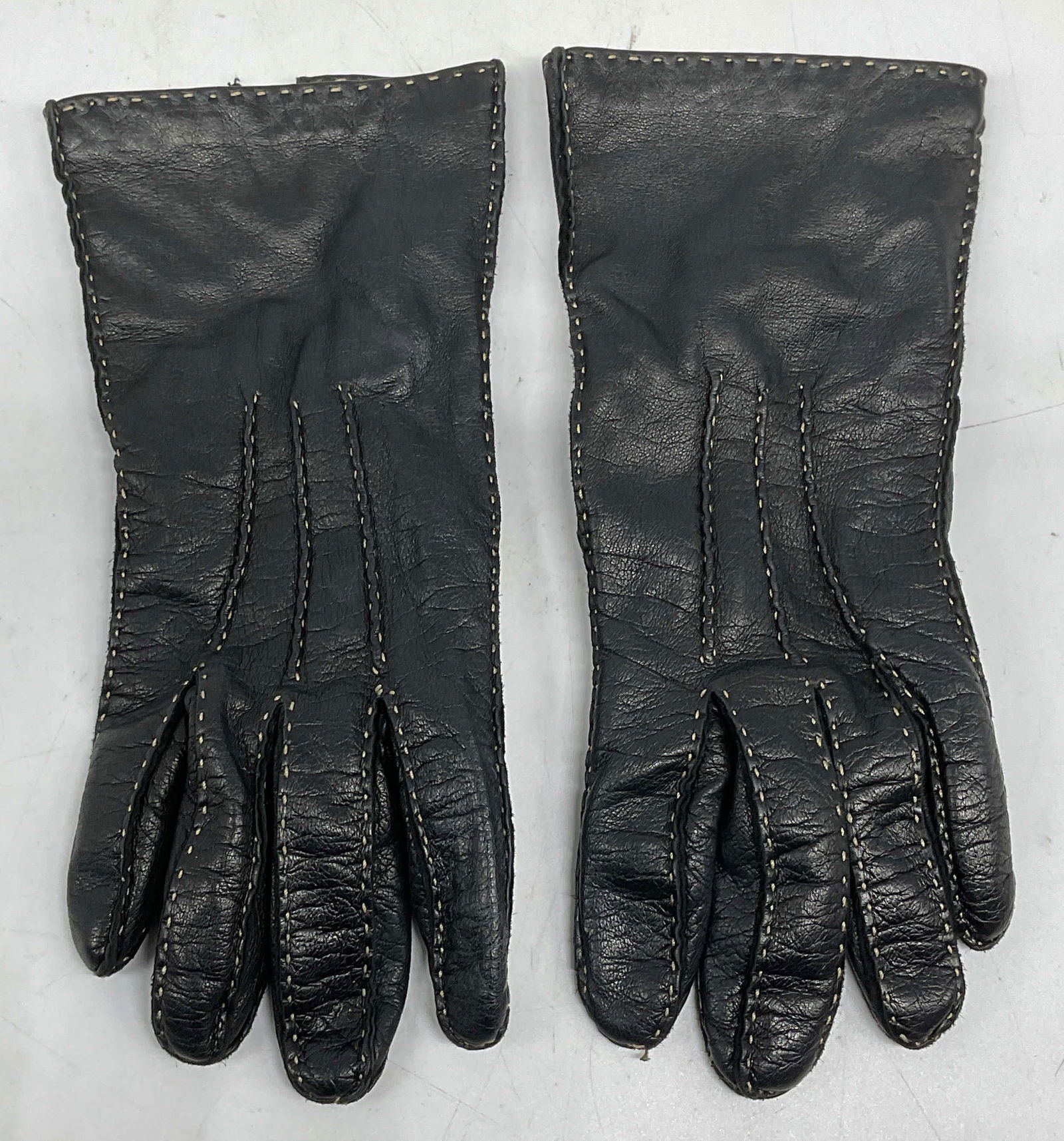 Coach Black Leather Silk Lined Gloves, Italy: Coach black leather gloves with contrast stitching and silk lining. Made in Italy. Measure approx 3 inches wide, 8.75 inches long. Some wear to leather consistent with exposure. Coach gloves, designer
