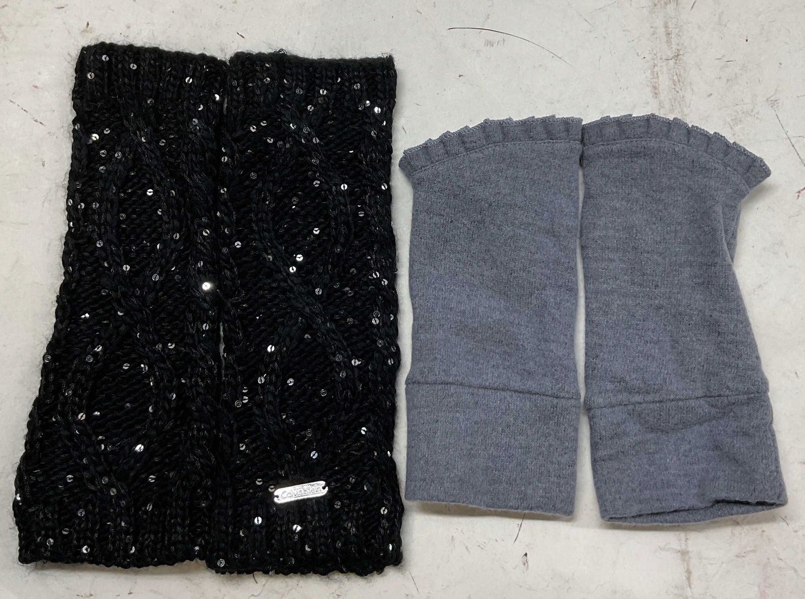 Lot 2 Pair Calvin Klein & 2 Chic Fingerless Gloves: Lot of 2 pairs of fingerless gloves. Calvin Klein black sequined fingerless gloves, acrylic and polyester blend, measures approx 3 1/2 inches wide x 10 inches long, knit like pattern. 2 Chic grey ruff