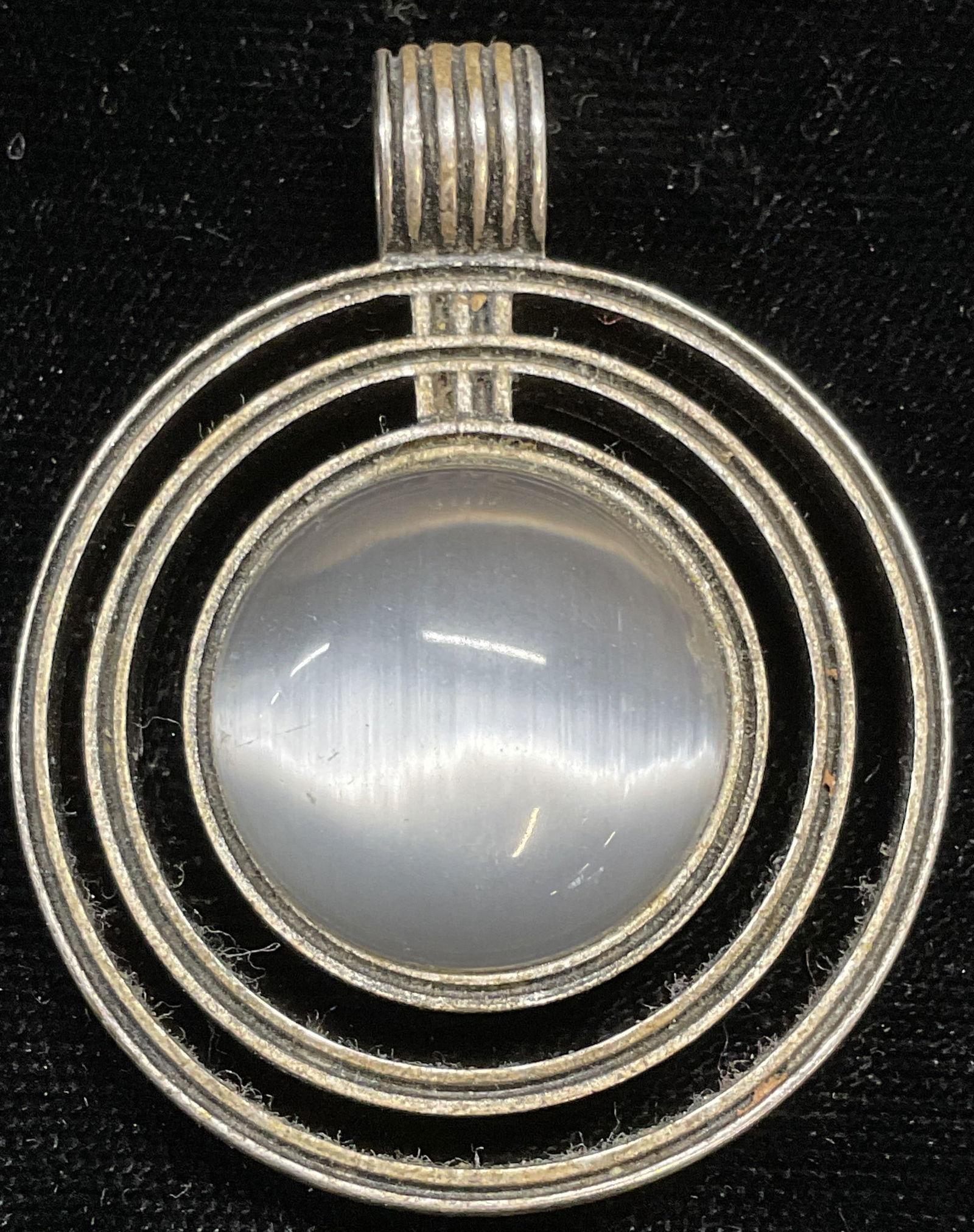 Lia Sophia Silver Tone Glass Circle Pendant: Signed Lia Sophia silver tone circle pendant with iridescent glass cabochon. Measures approx 1.5 inches wide. Some scratching. Jewelry, estate jewelry, costume jewelry, cocktail jewelry, fashion jewel