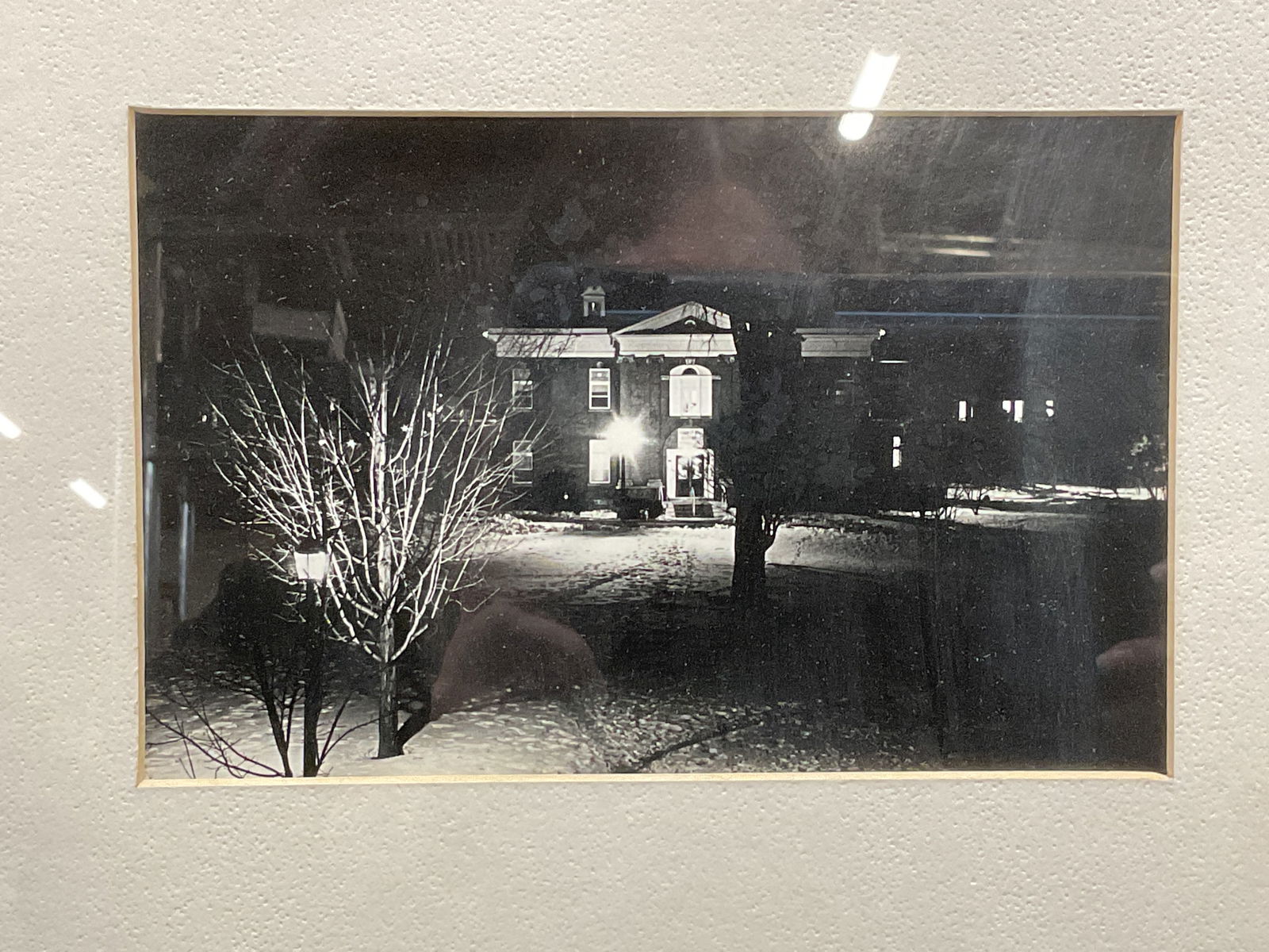 Framed Black & White Winter Scene Photo: Framed and matted black and white photograph. Winter scene, exterior of a building at night. Silver tone metal frame. Not examined out of frame. Frame measures approx 11.25 x 14.25 inches. Some wear c