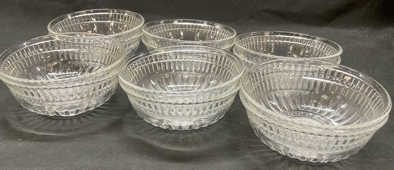 Set 12 Vintage Glass Serving Bowls: Set of 12 vintage glass serving bowls. Circular bowls. Ribbed pattern along rim and base. Measures ht approx 2 inches diam approx 5 inches. Surface wear consistent with exposure. Bowls, serving bowls,