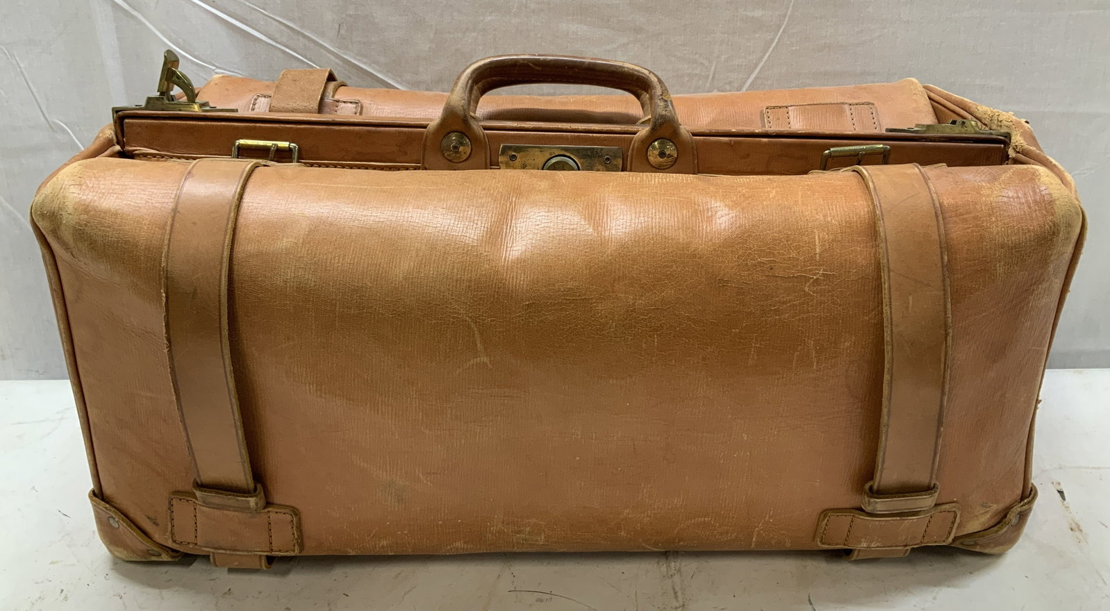 Vntg INR Orange Leather Gladstone Style Bag: Appears locked, no key. Interior is not examined. Piece is orange toned & leather. Features gold toned hardware & buckles for securing straps. Double handled. Signed & marked. Reads, SECURE ENGLISH EV