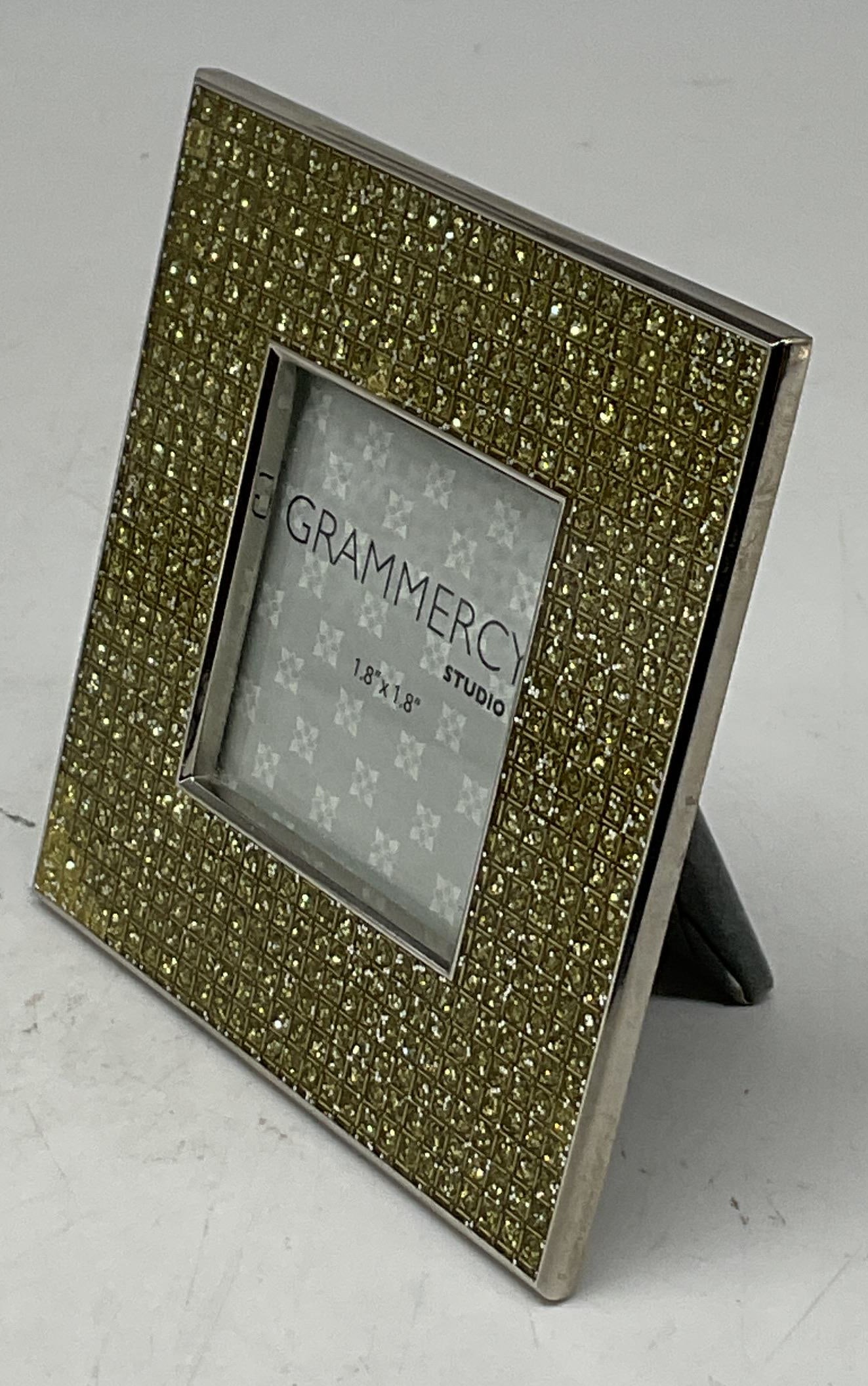 Grammercy Studio Metal Textured Frame: Grammercy Studio metal textured frame. Grid design with a sparkly appearance. Textured appearance. Yellow gold tone. Silver toned border. Picture size measures 1.8 x 1.8 inches. Frame size measures ap