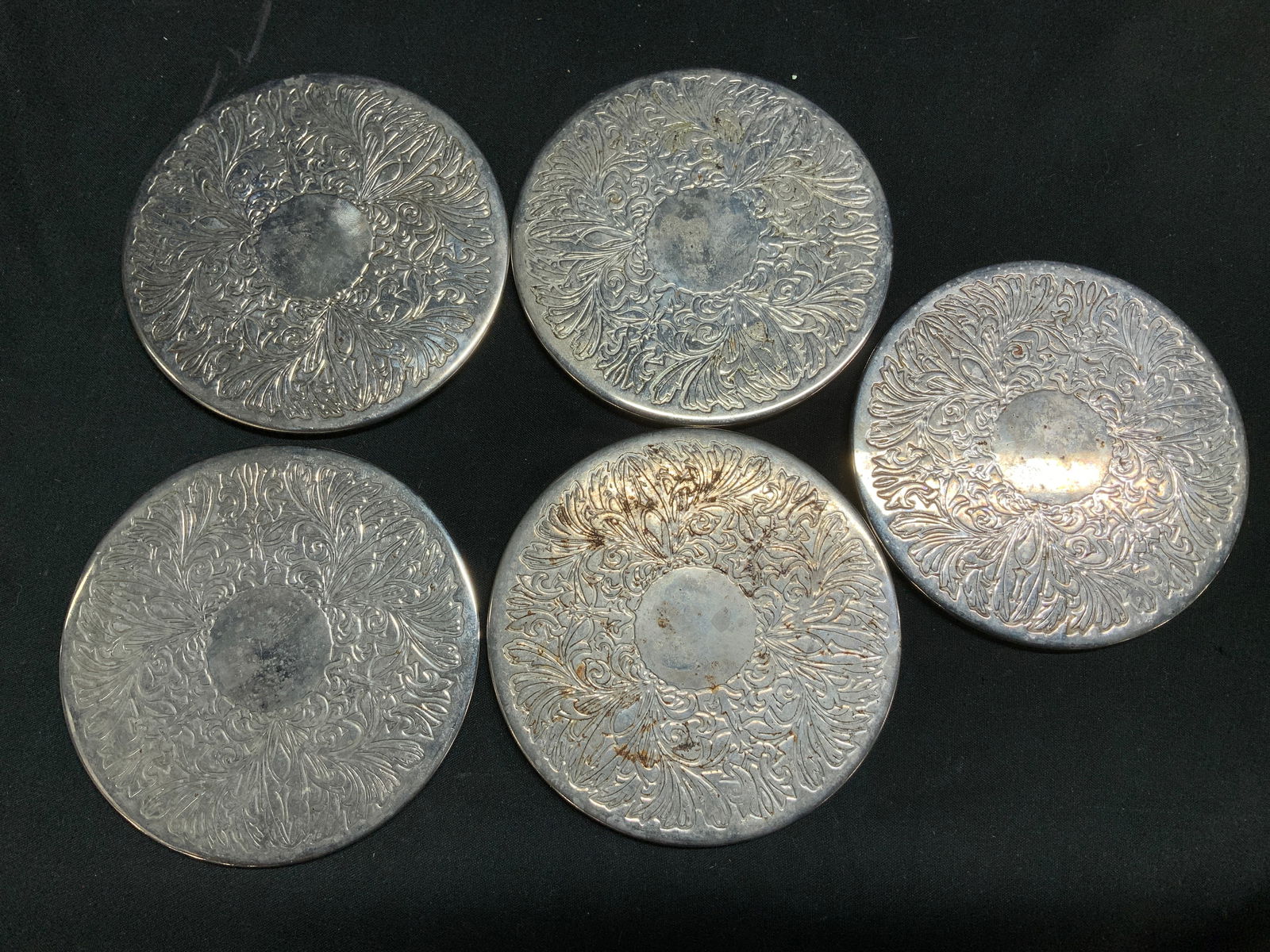 Set 5 Folgers Silver Plated Coasters HONG KONG: Lot includes, set 5 of silver plated coaster. Coasters features intricate, embossed floral patterns. Signed & marked. Reads, FOLGERS HONG KONG. Surface wear consistent to age, use & exposure. Measurem