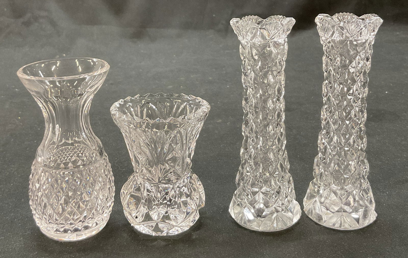 Lot 4 SGND Waterford Crystal+ Glass Bud Vases: Lot of 4 bud vases. Includes signed Waterford crystal bud vase. Diamond style pattern with flared rim, faceted neck, and starburst design on underside. Signed on underside, reads as follows Waterford.